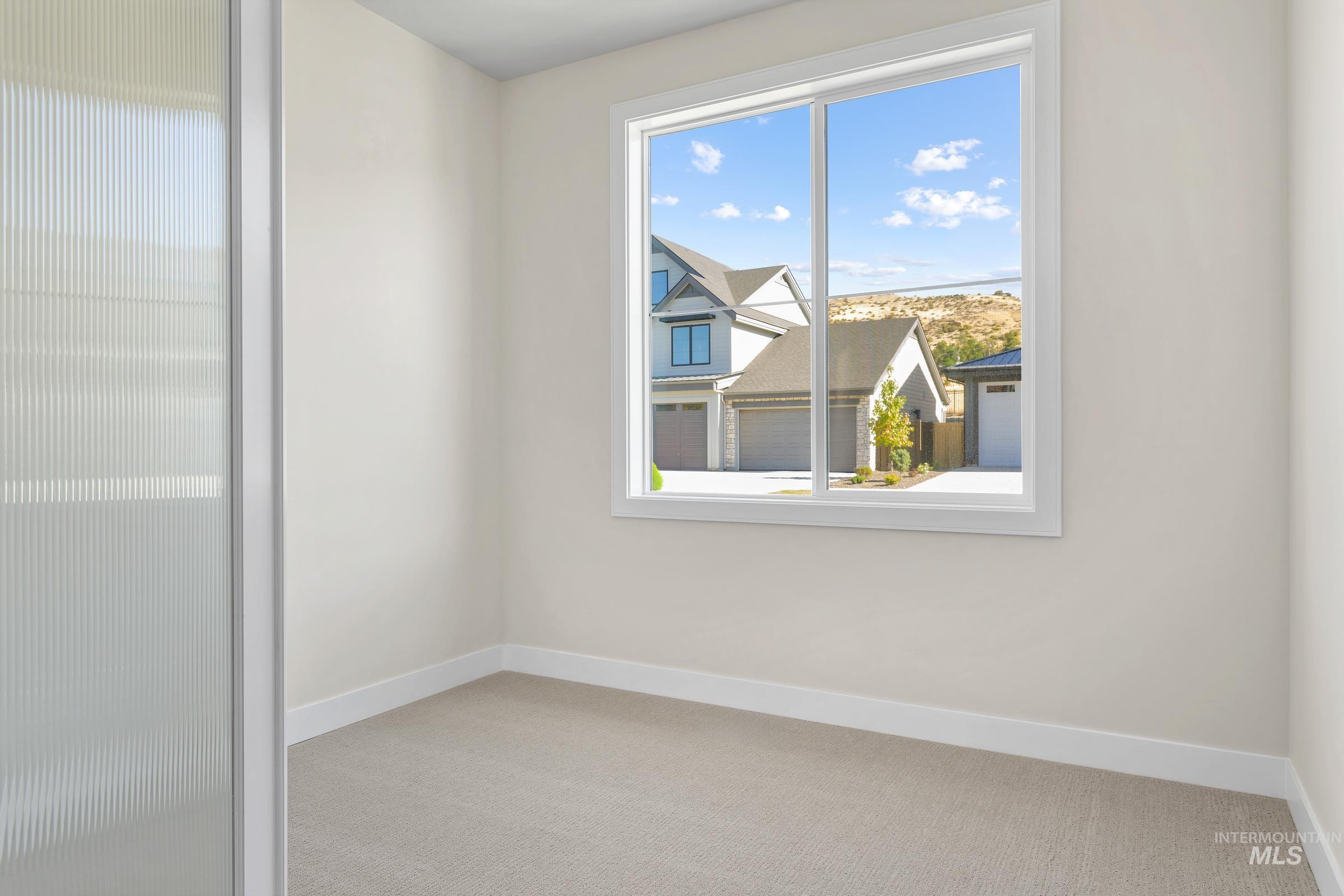 Spare room featuring baseboards and light colored carpet