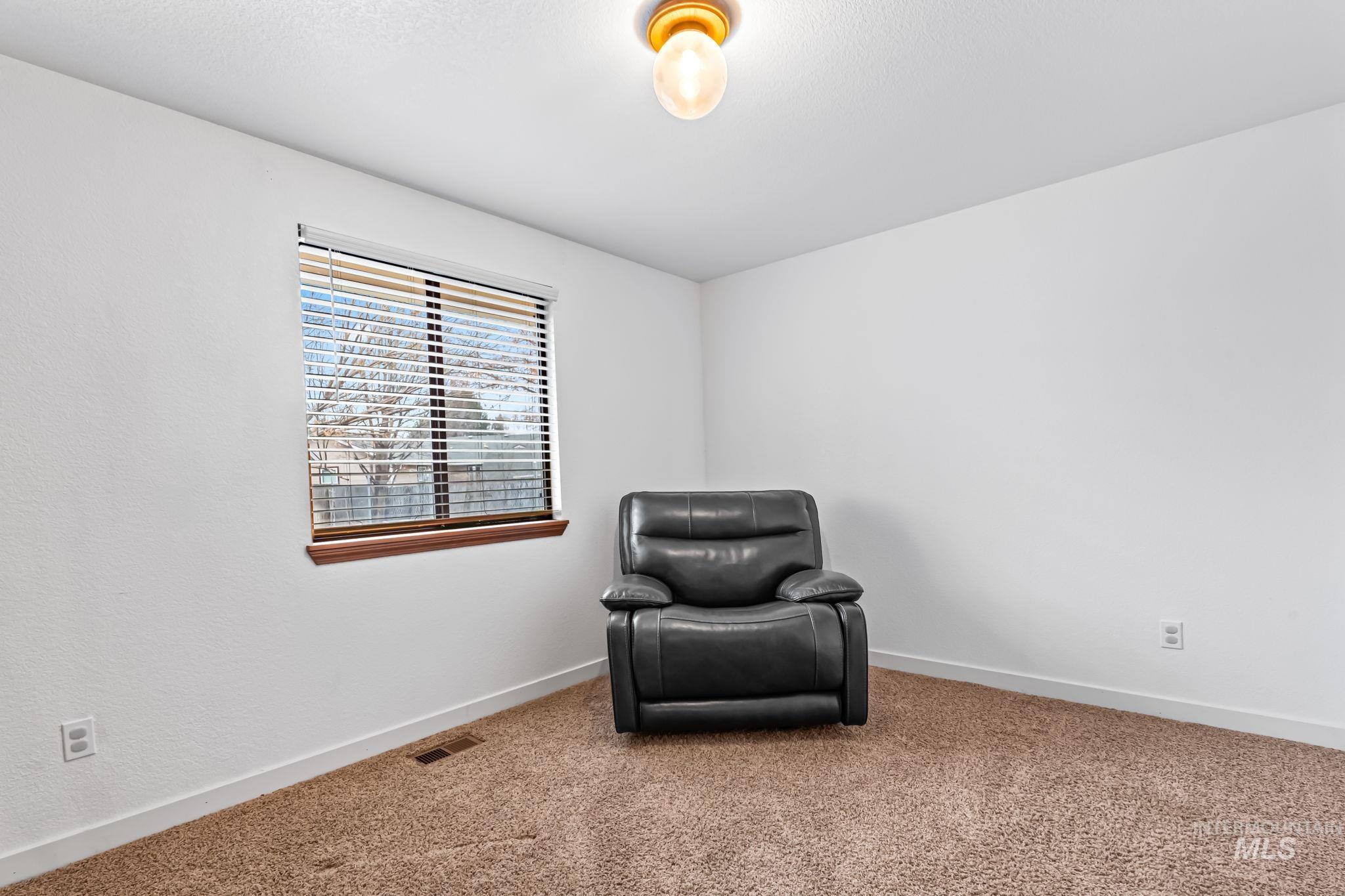 Sitting room featuring carpet flooring and baseboards