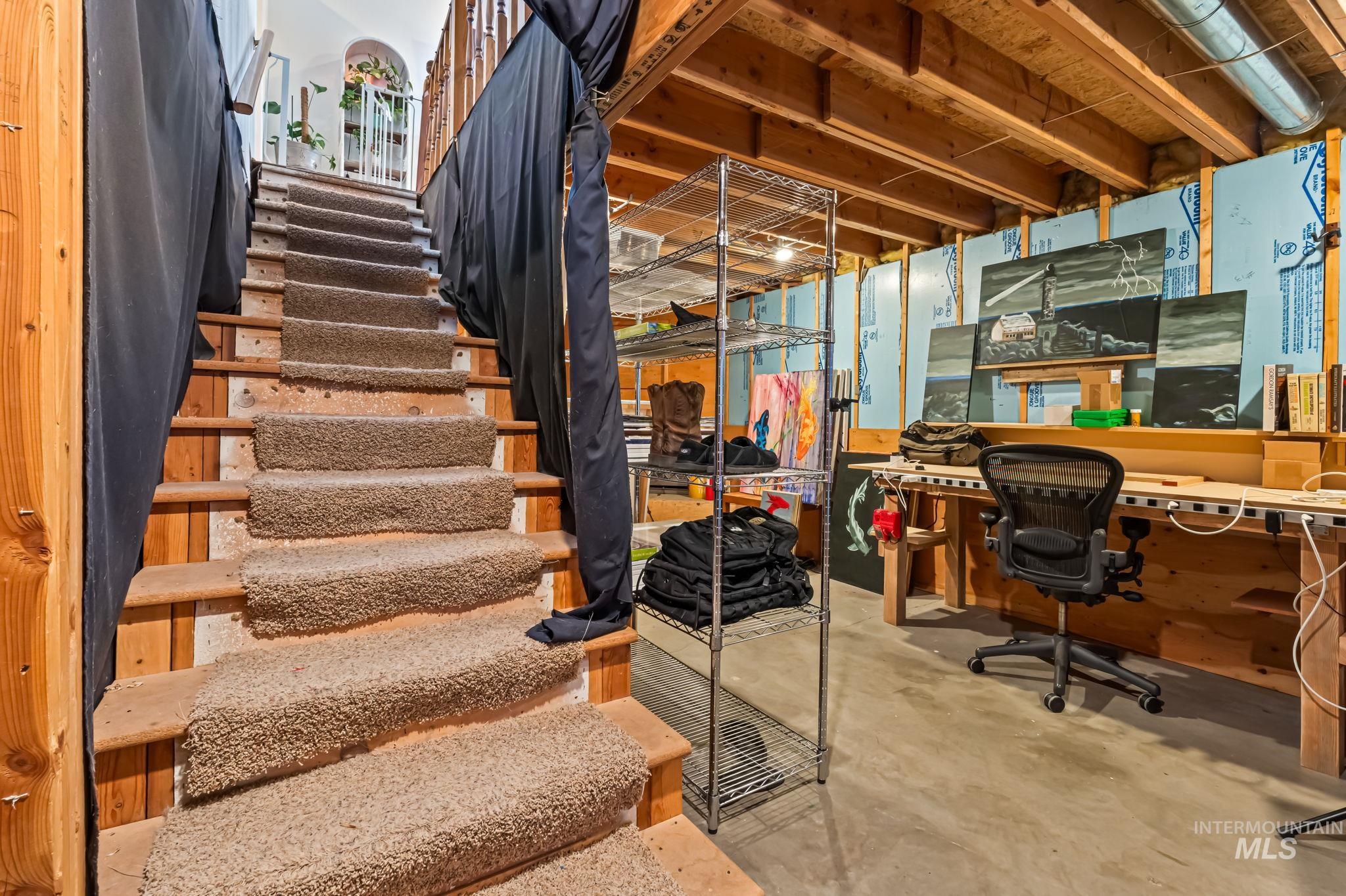 Unfinished below grade area with stairway and a desk