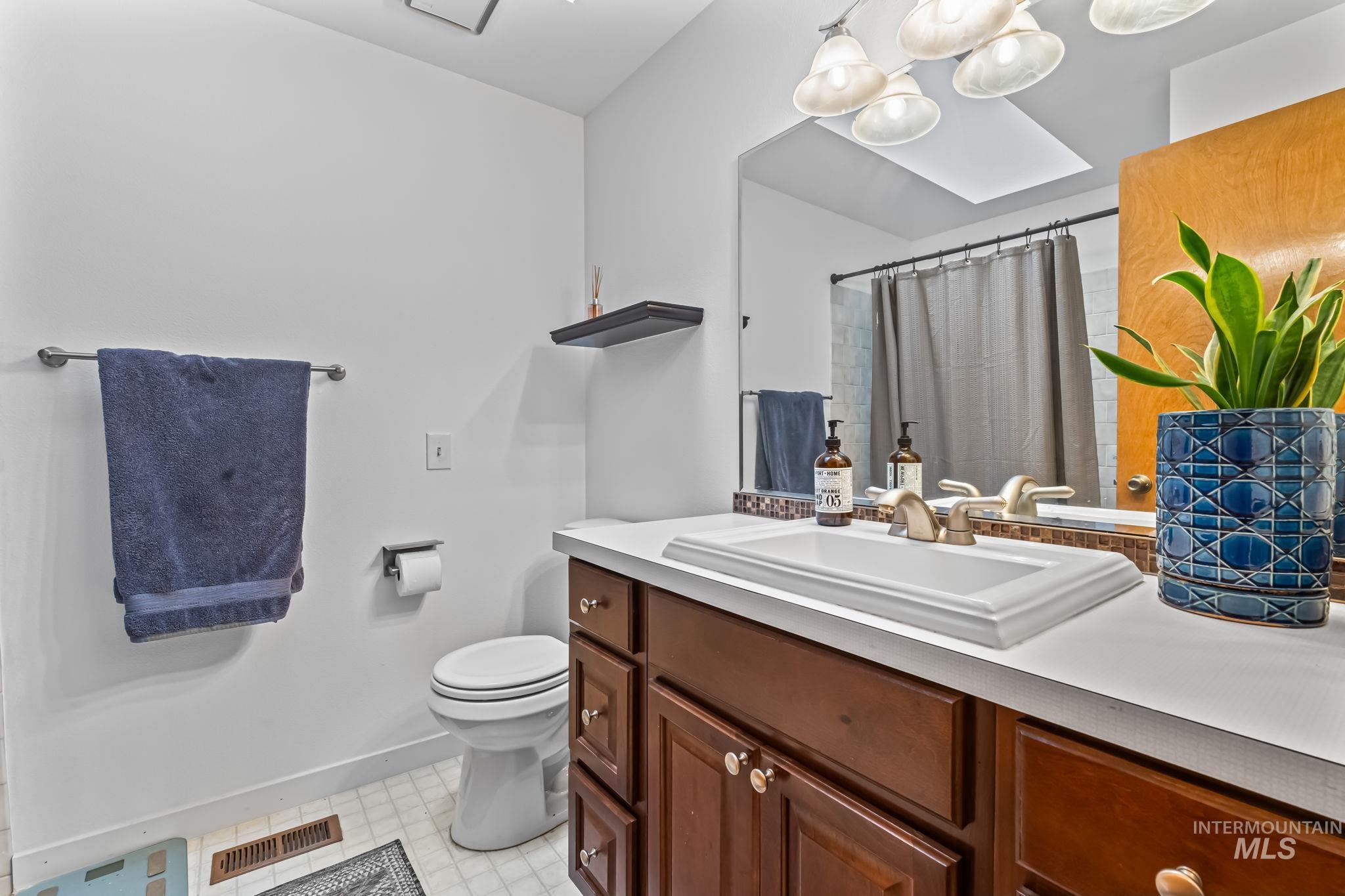 Bathroom featuring vanity, curtained shower, and light flooring