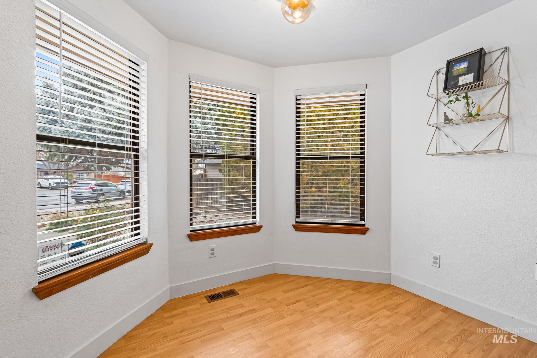 Empty room with light wood-style flooring and a textured wall