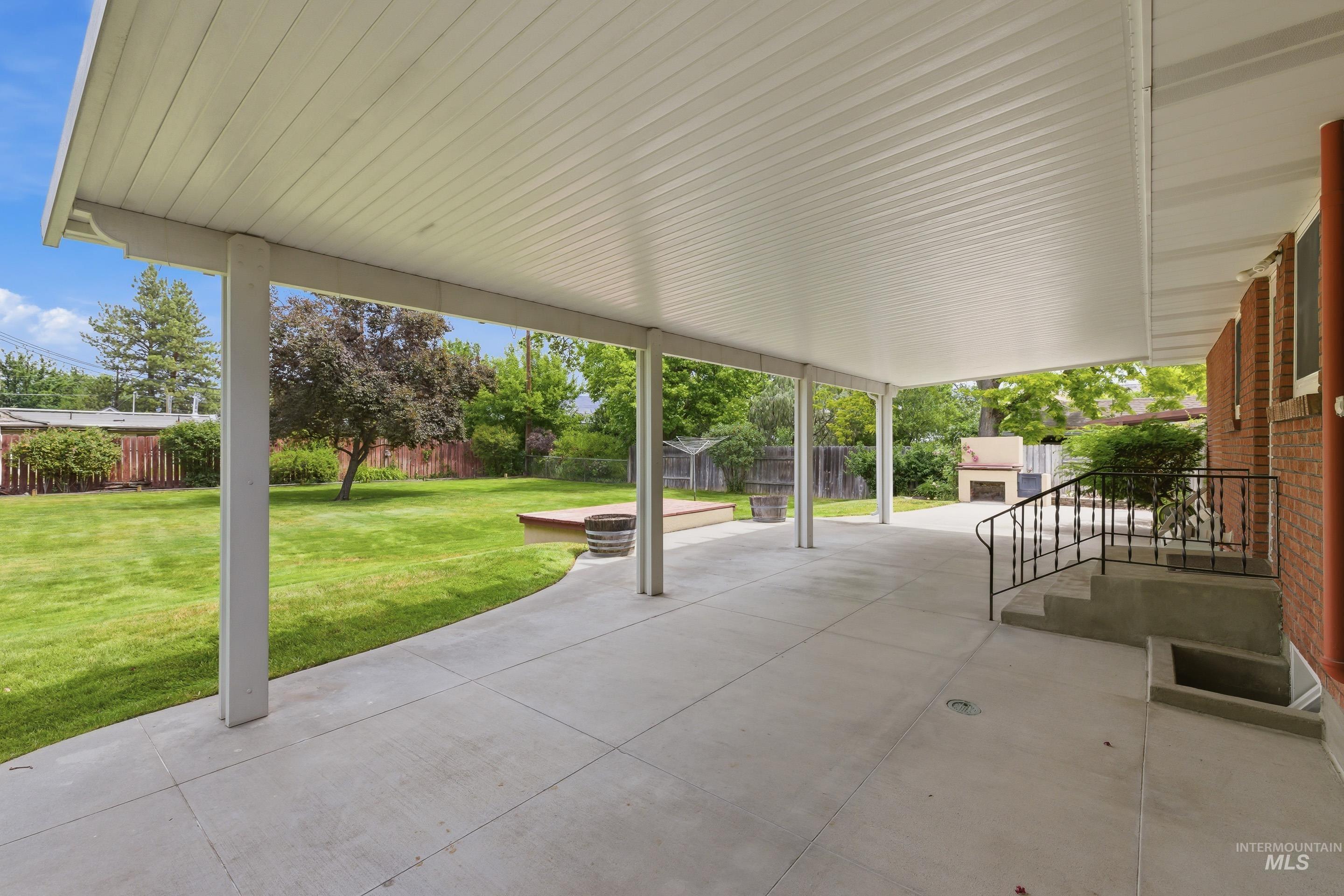 Expansive covered concrete patio with multiple support columns