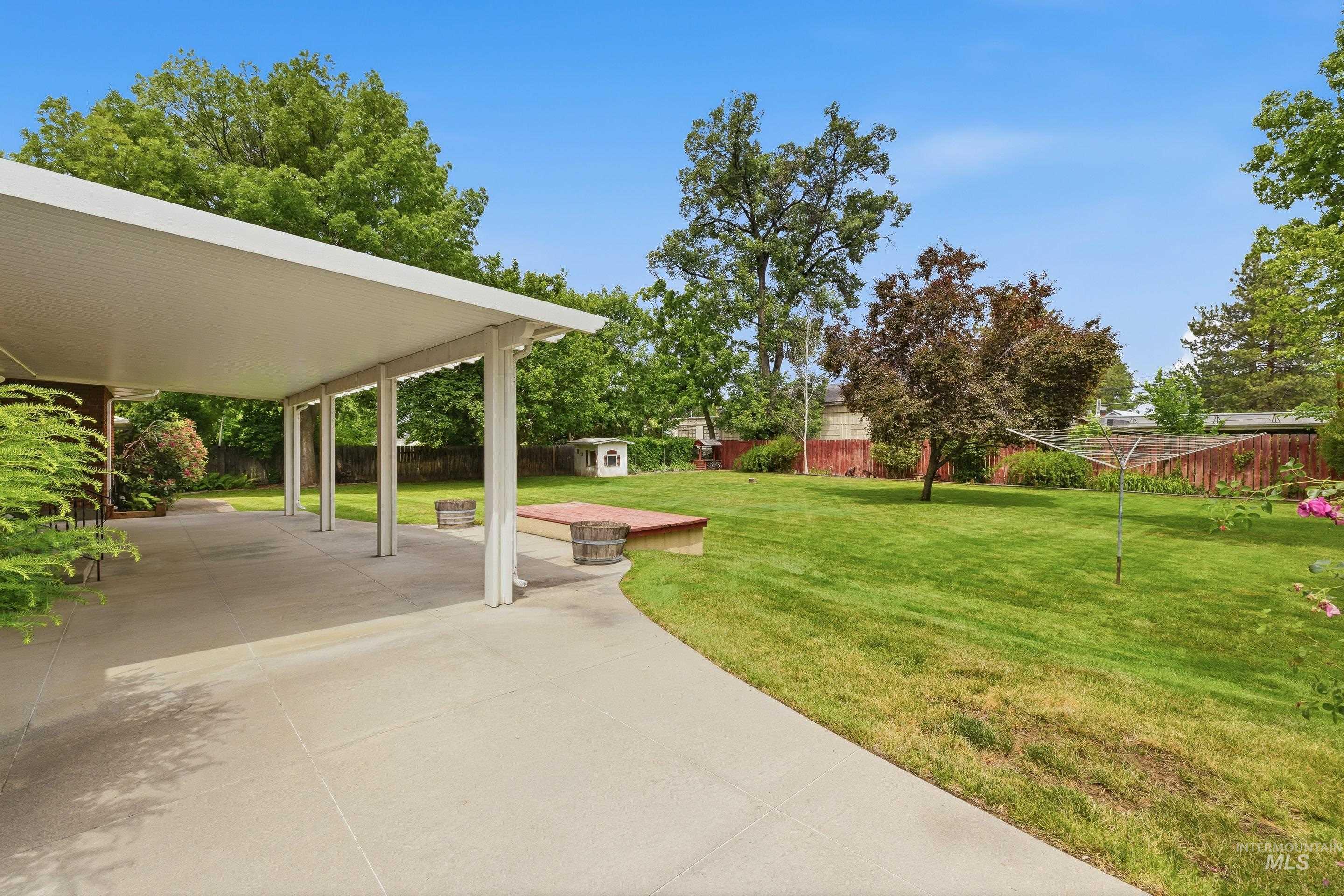Expansive concrete patio with a white covered awning, offering generous outdoor living space