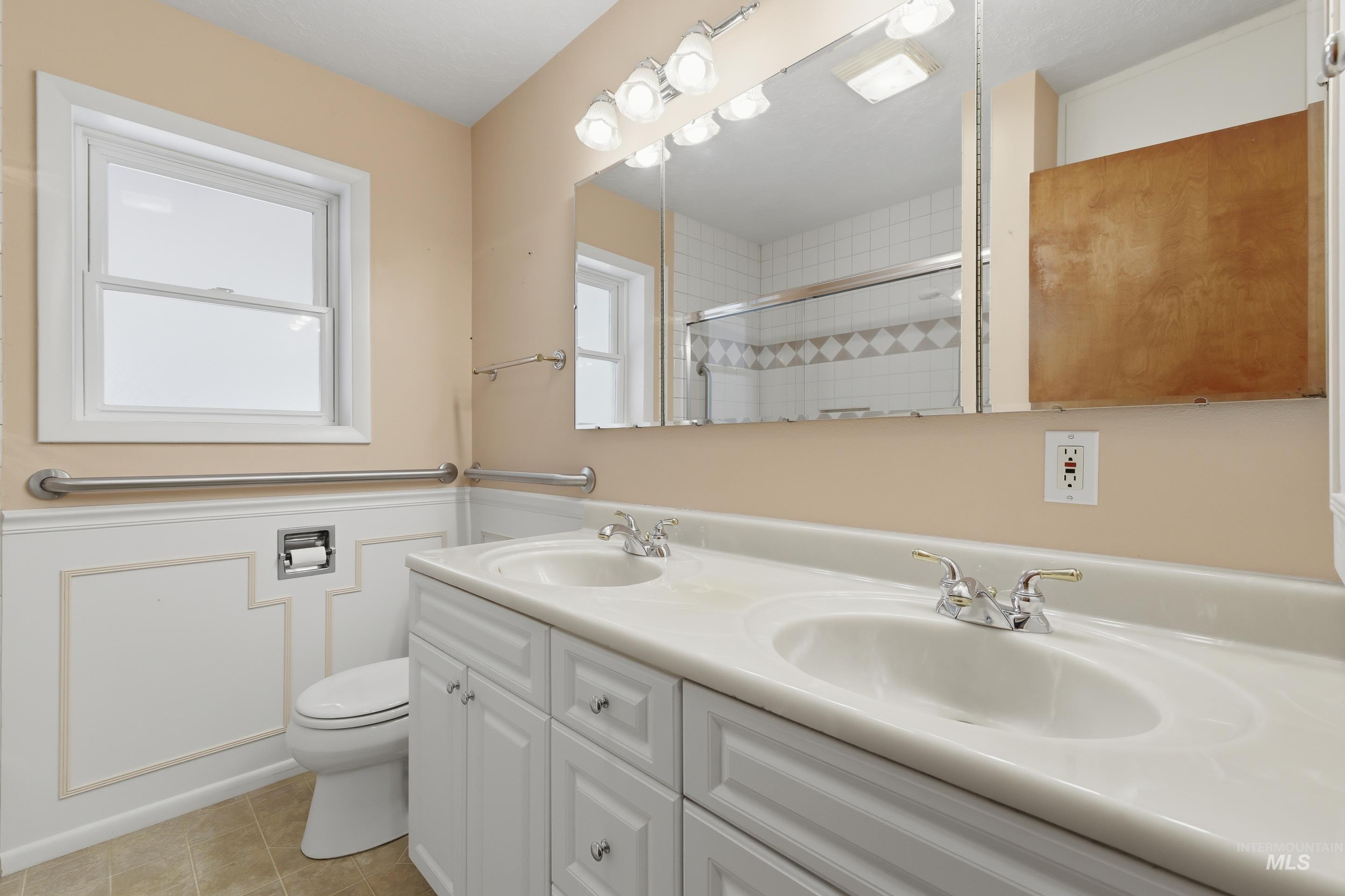 Dual vanity with integrated sinks, white cabinetry, and polished chrome faucets