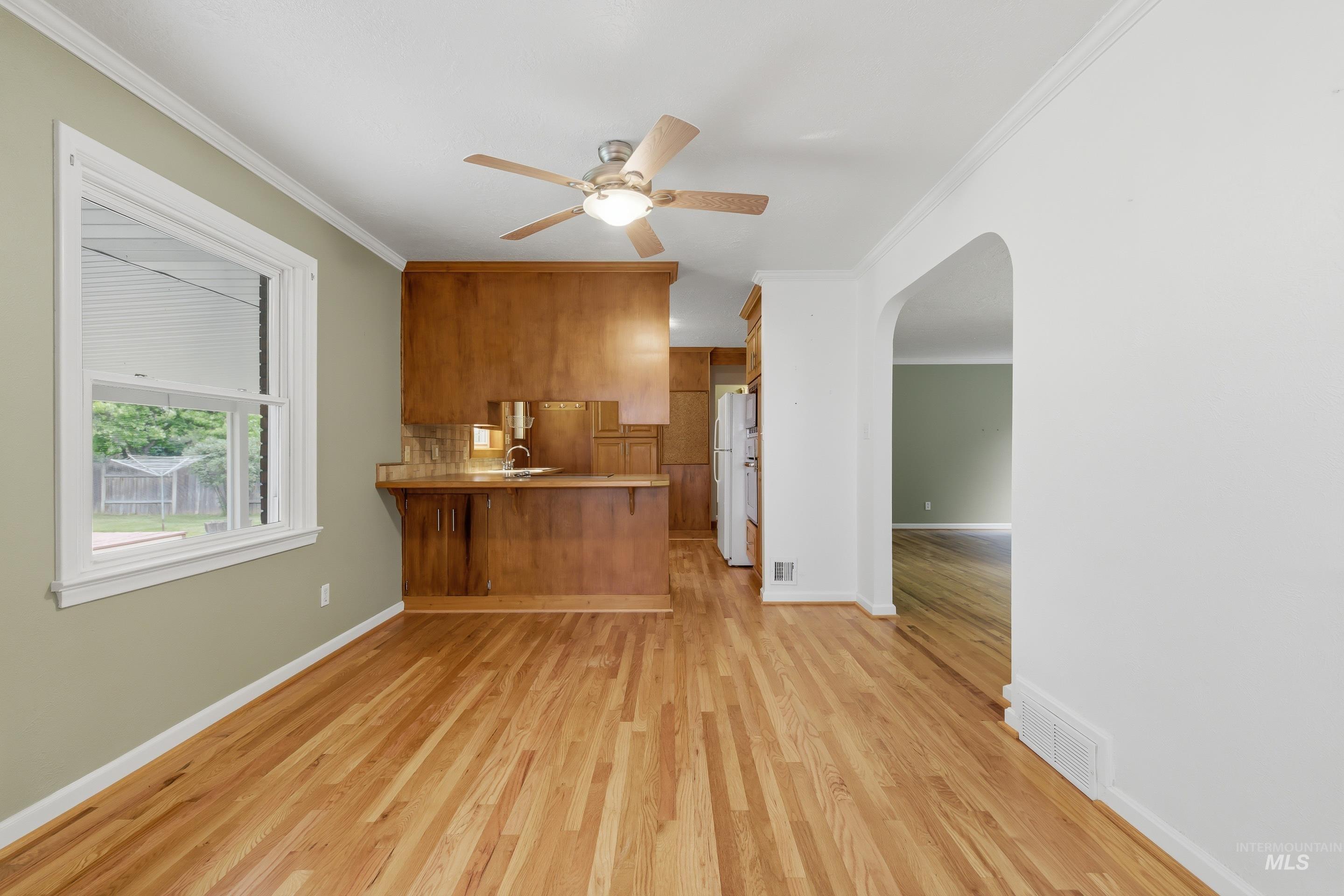 Hardwood flooring spanning the room, featuring a built-in wood-finish cabinet with a countertop