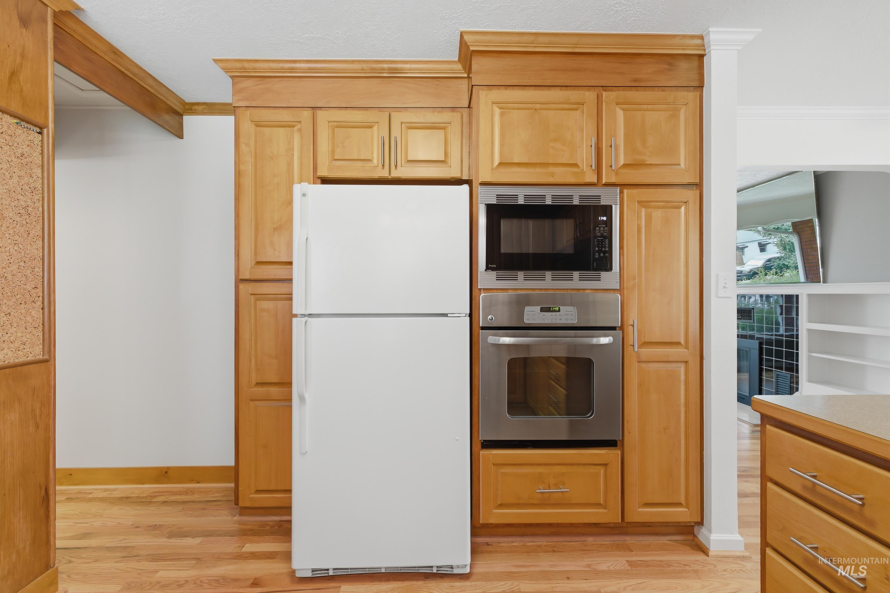 Kitchen featuring wood-finish cabinetry and flooring