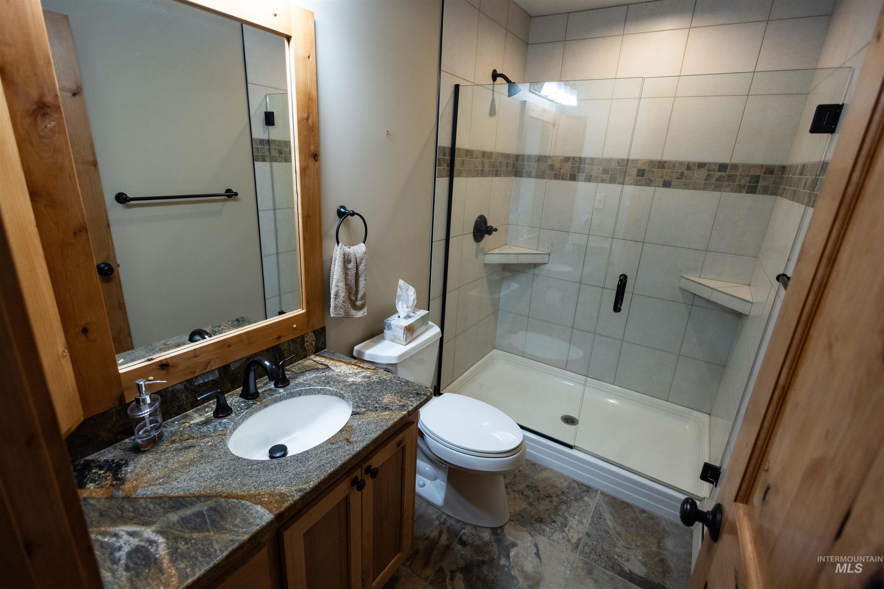 Full bath with vanity and a shower stall
