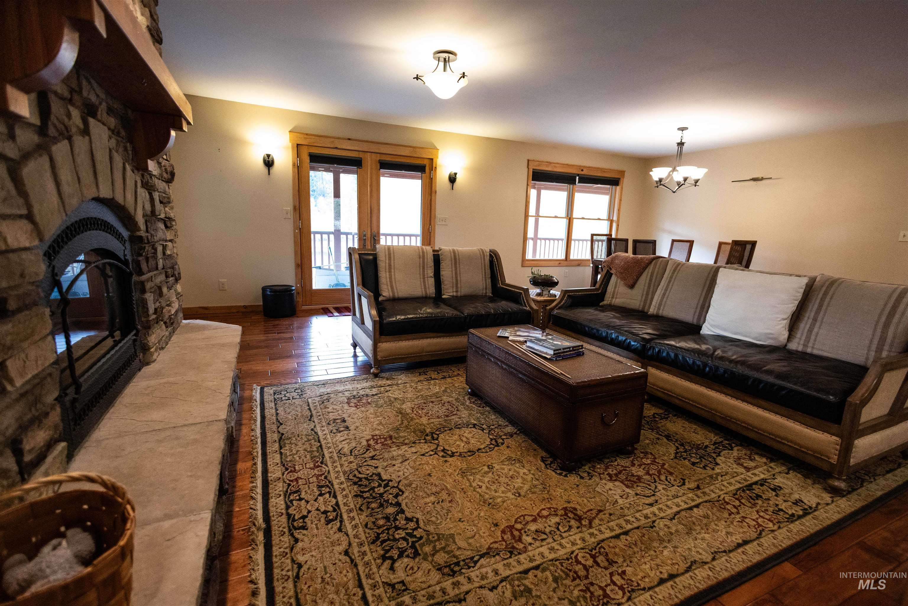 Living area featuring hardwood / wood-style floors, a fireplace, plenty of natural light, and a chandelier