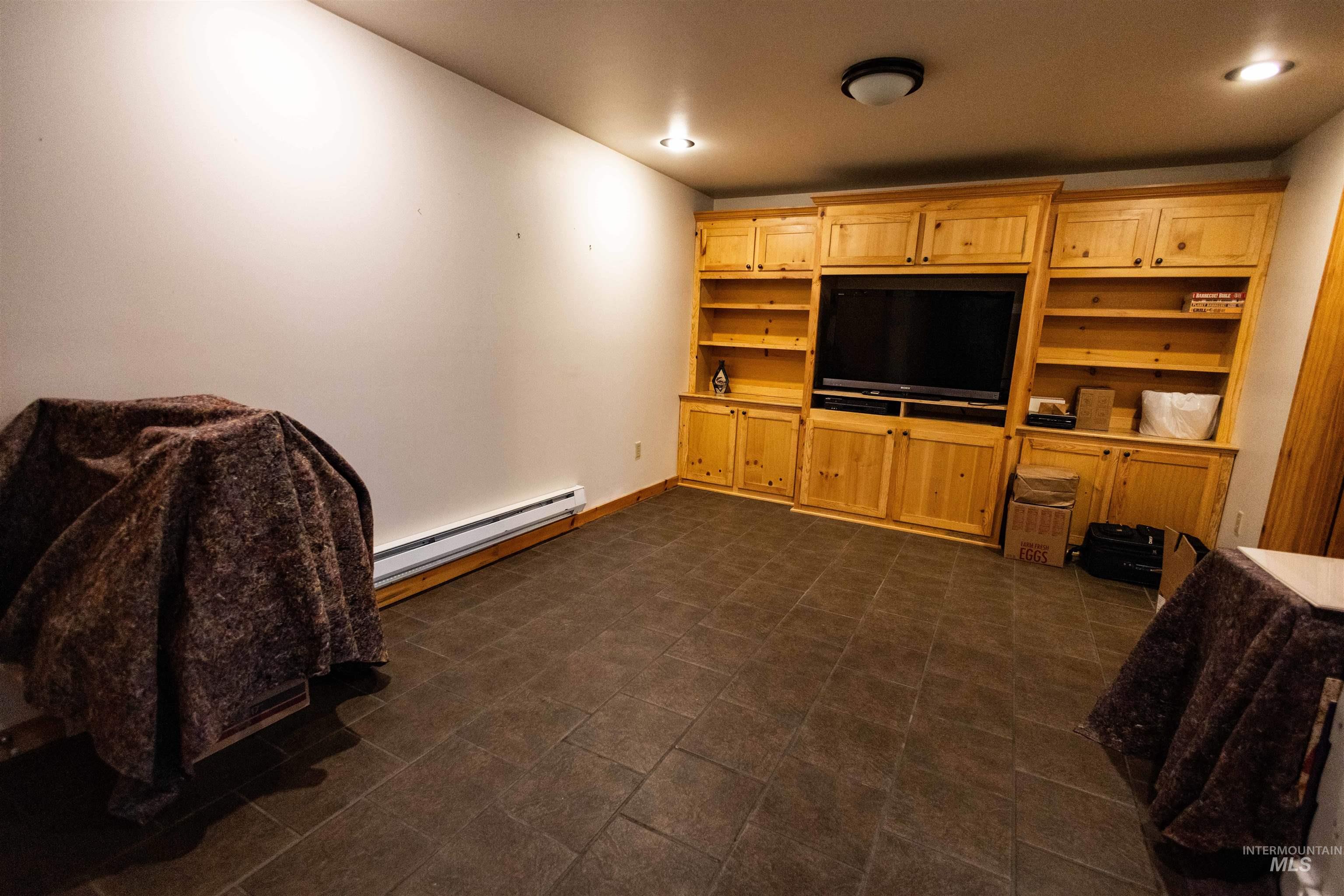 Living area featuring a baseboard heating unit and recessed lighting