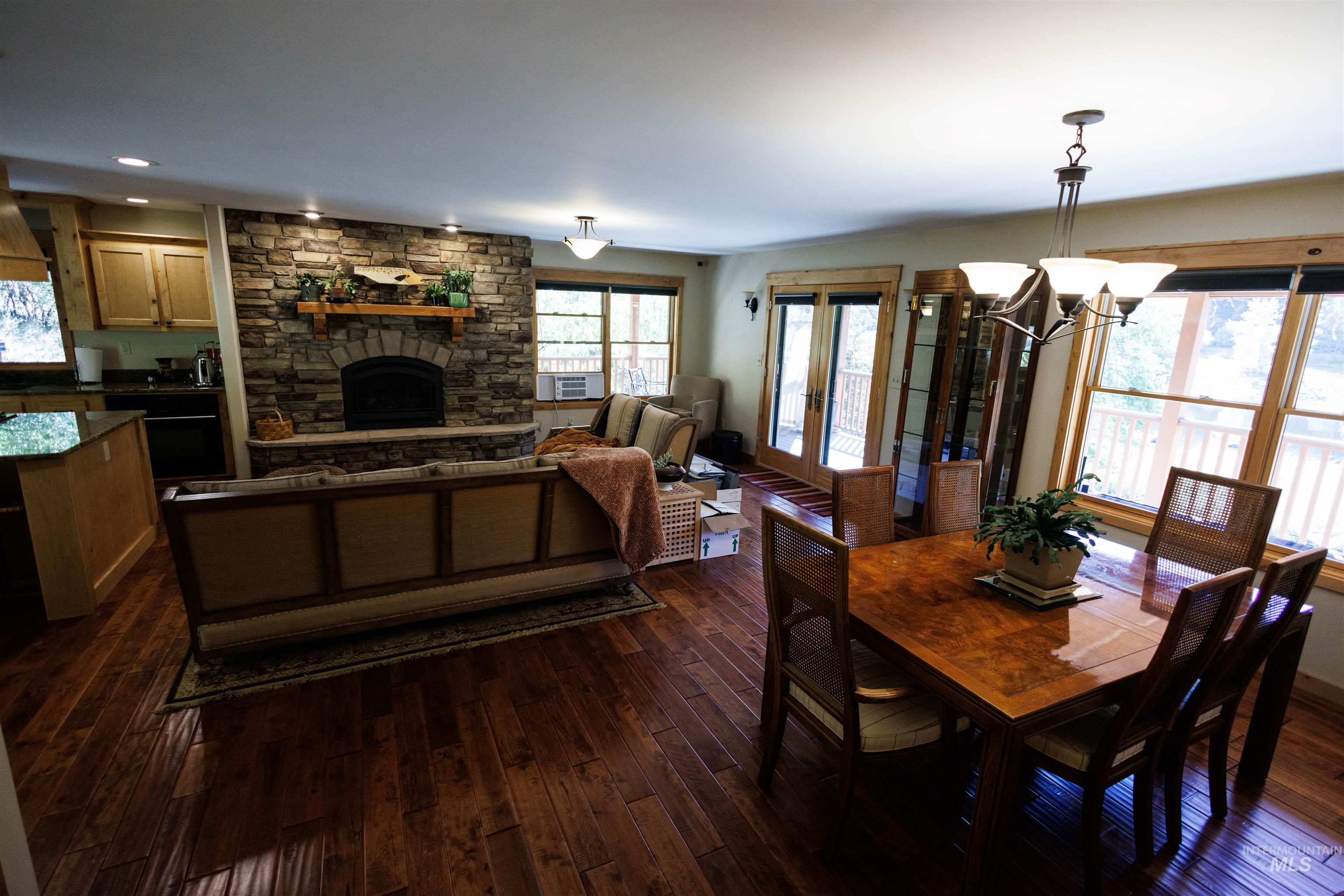 Dining space with dark wood finished floors, a fireplace, and a chandelier
