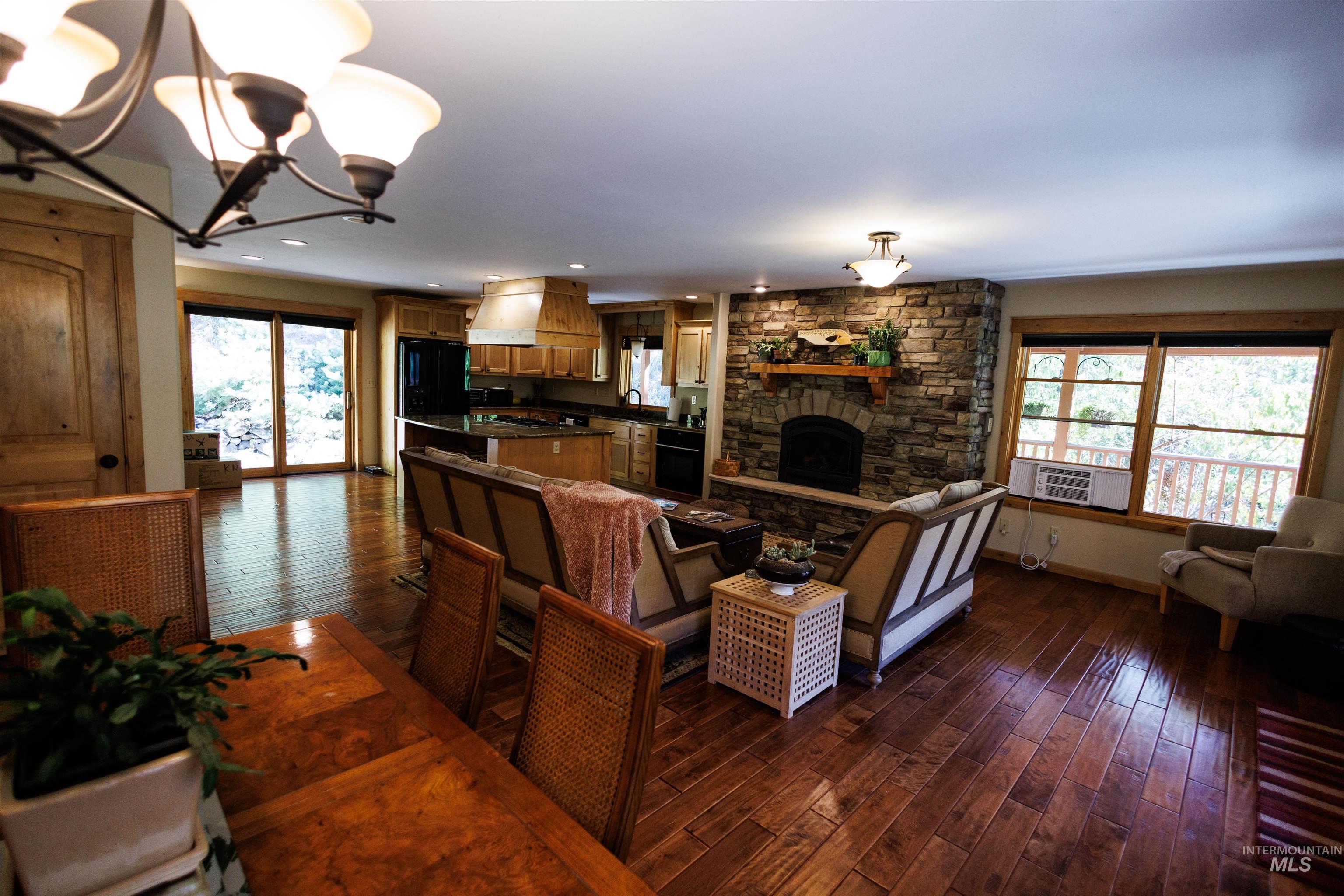 Living room featuring a chandelier, dark wood-type flooring, and a fireplace