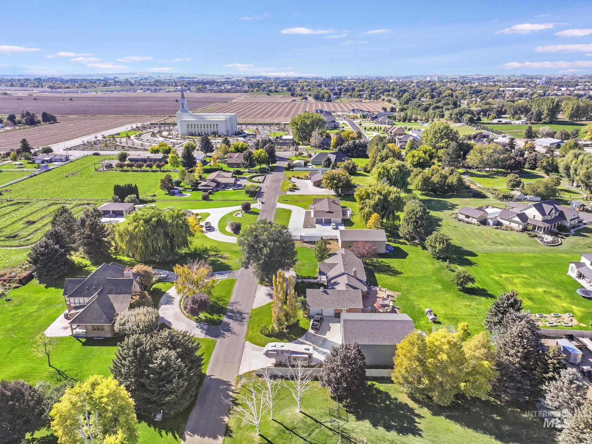 Aerial view of sparsely populated area featuring nearby suburban area and farmland