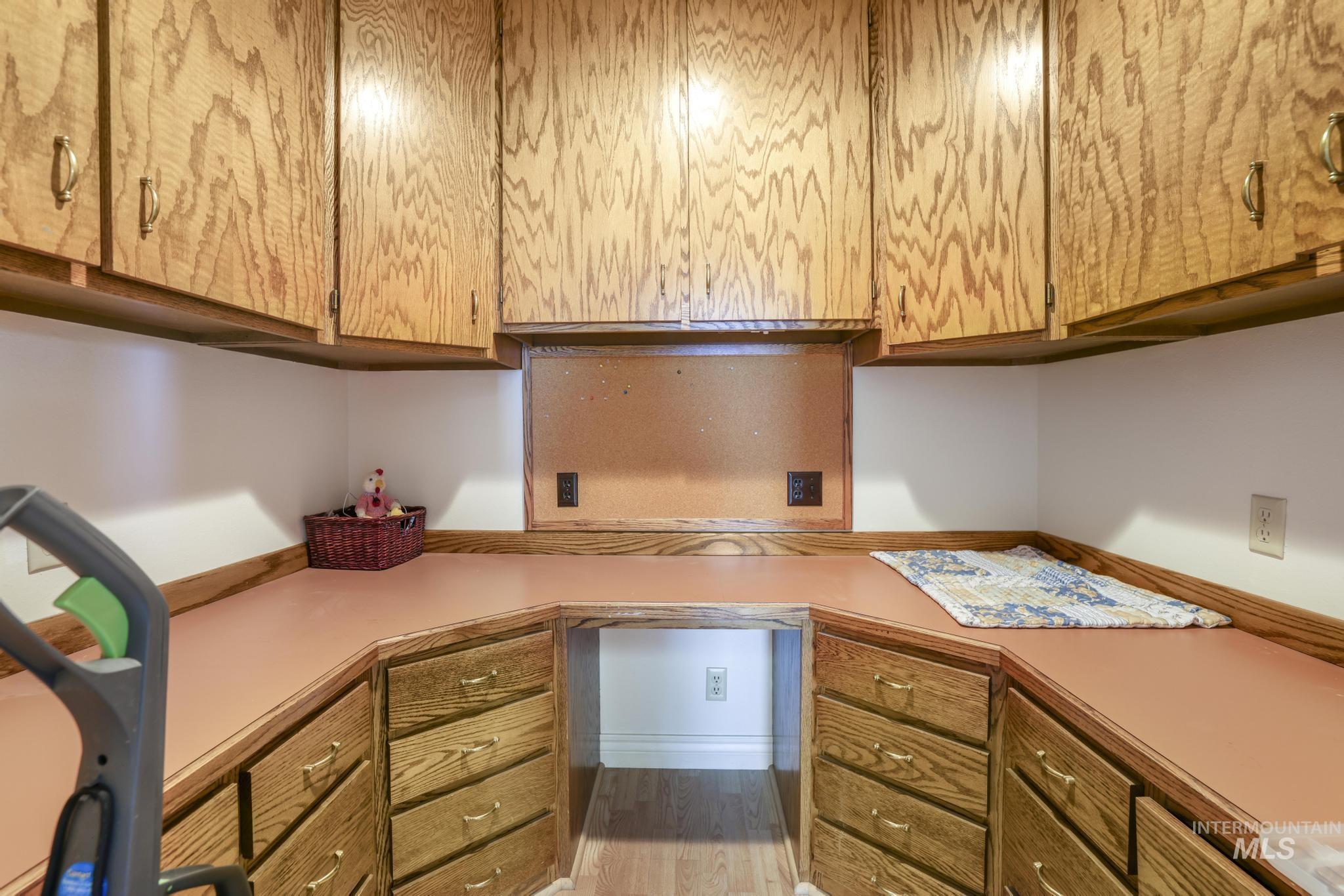 Kitchen featuring built in study area, light countertops, and wood finished floors