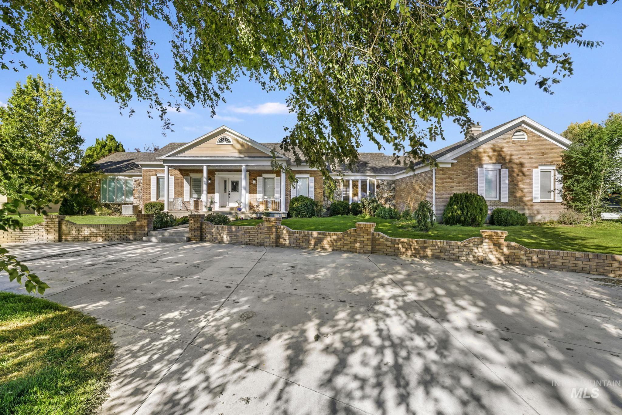 View of front of house featuring covered porch, brick siding, and a front lawn