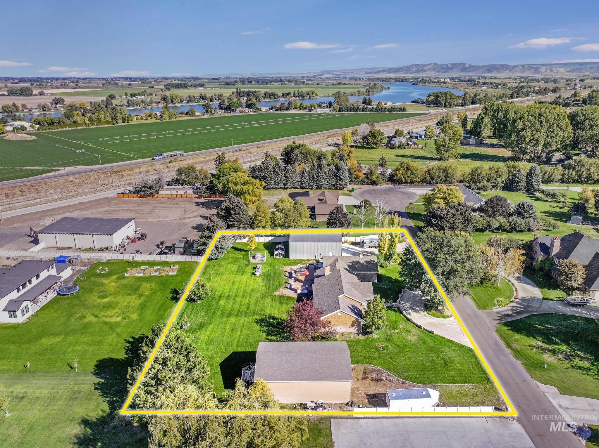 Aerial perspective of suburban area featuring a nearby body of water and property boundaries highlighted