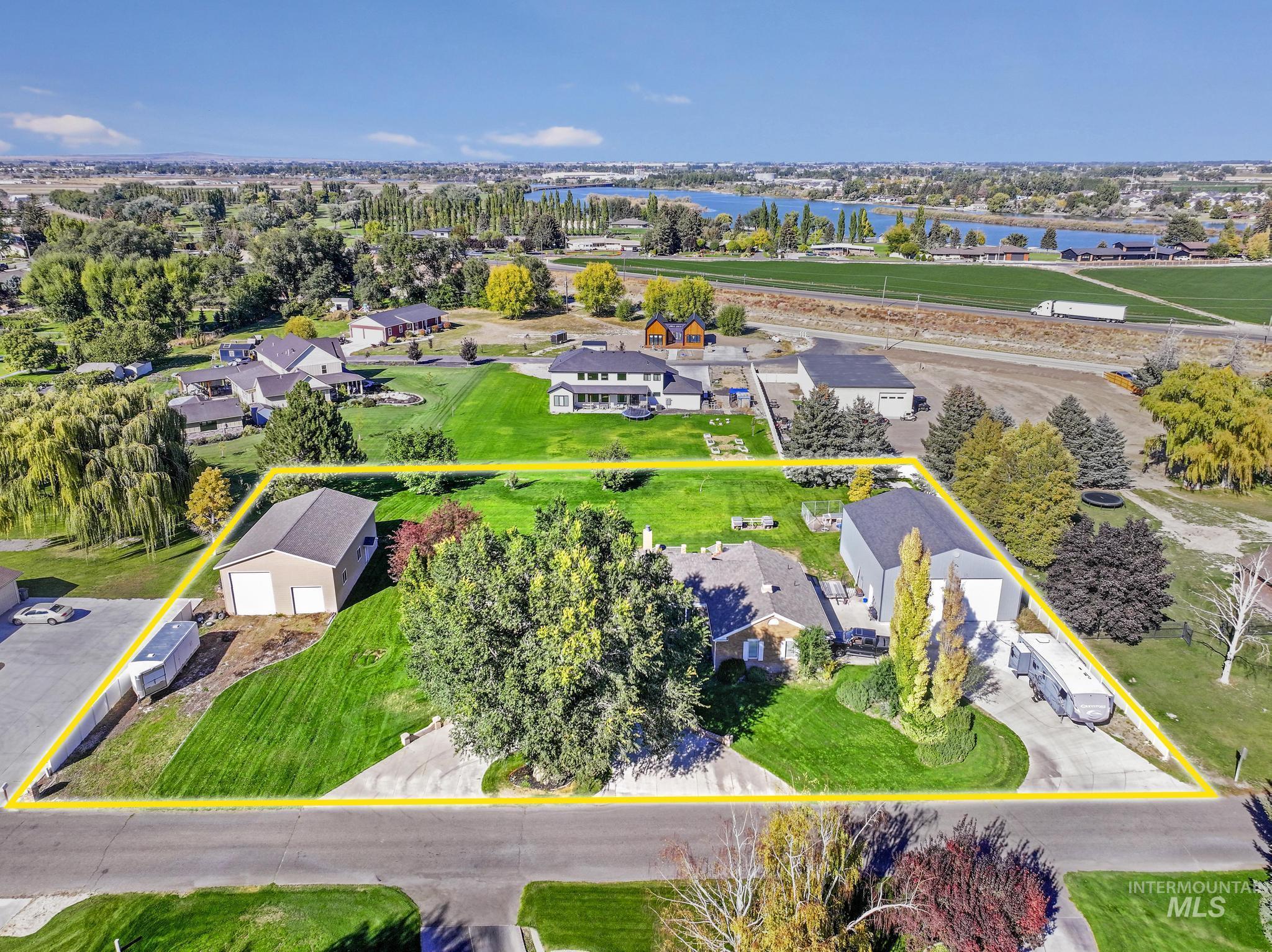 Aerial view of residential area featuring a large body of water and property parcel outlined