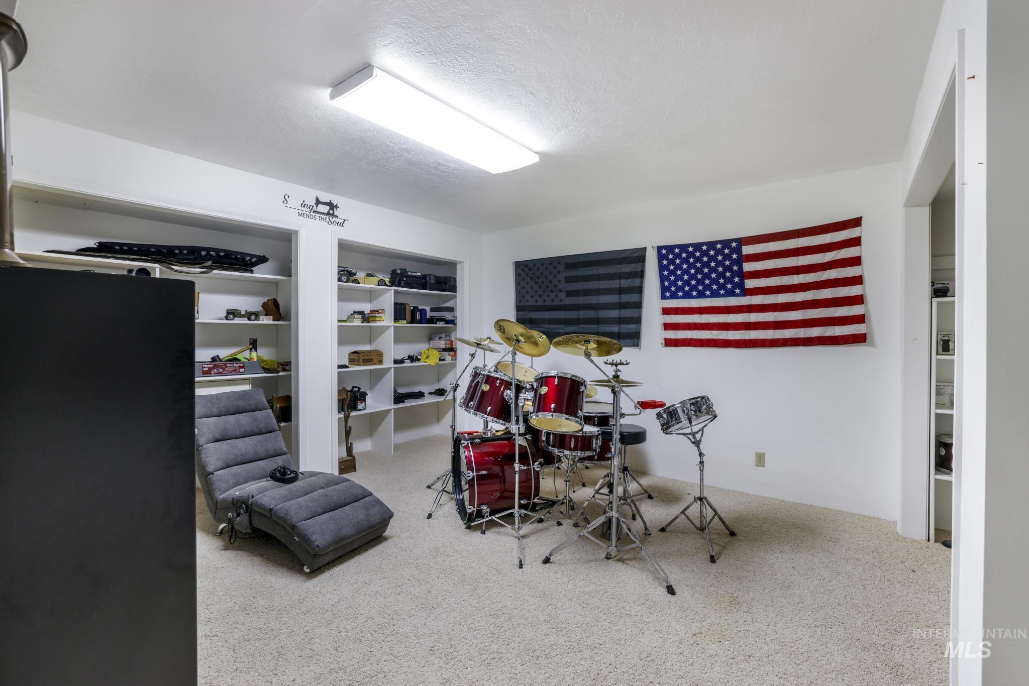 Recreation room with carpet floors and a textured ceiling