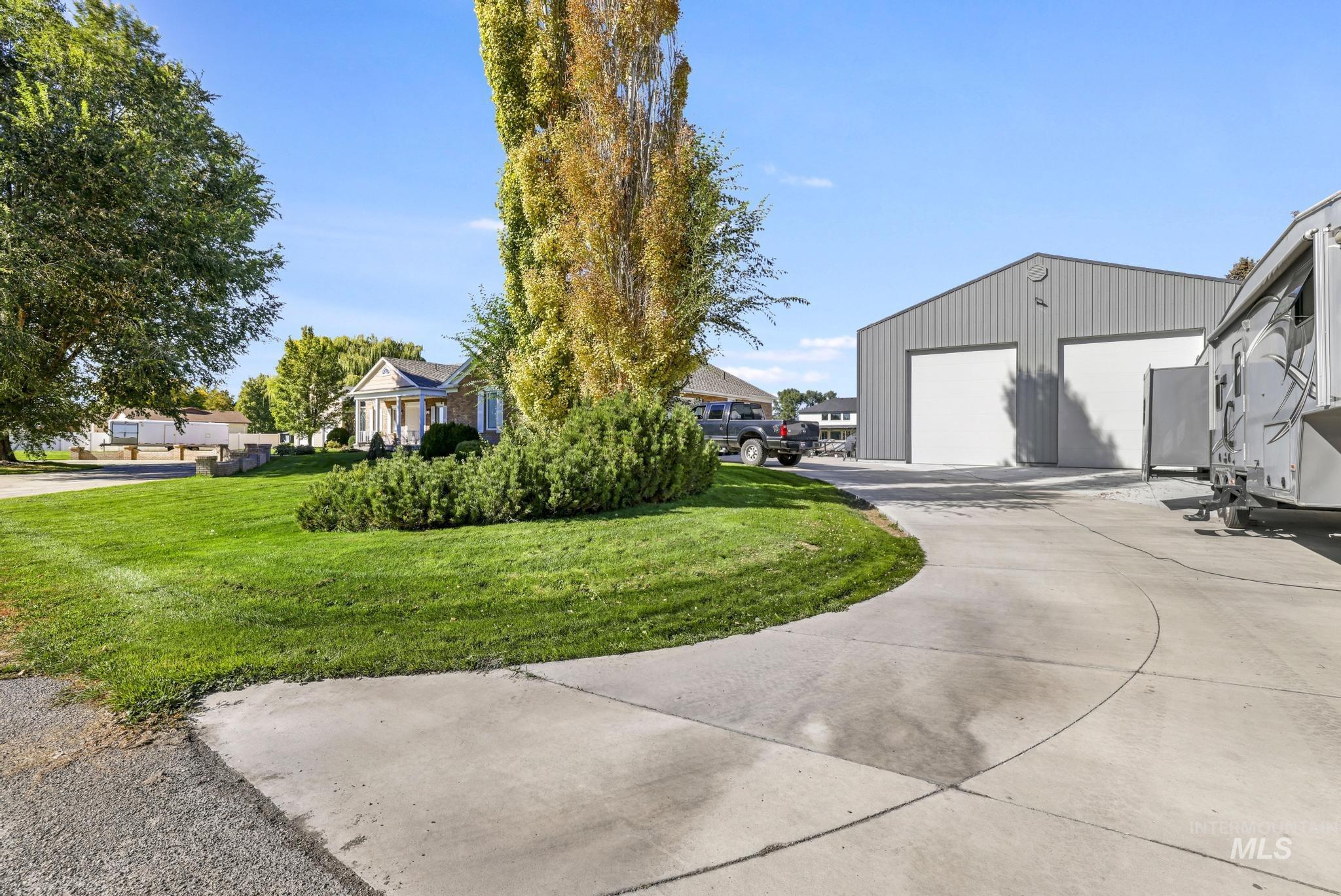View of green lawn with an outdoor structure and a residential view