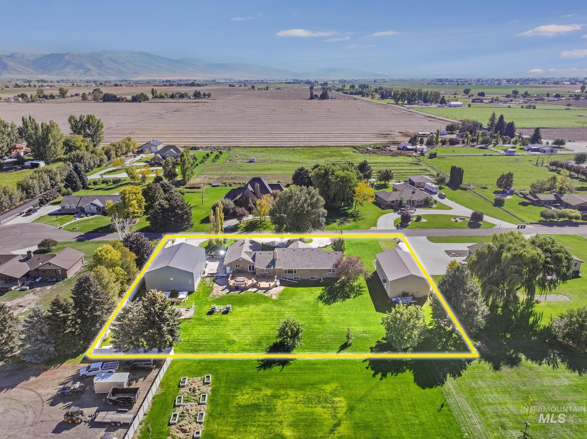 Aerial view of sparsely populated area featuring property parcel outlined and a mountain backdrop