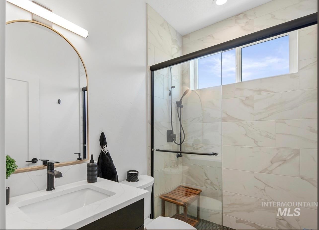 Full bath with vanity and a marble finish shower