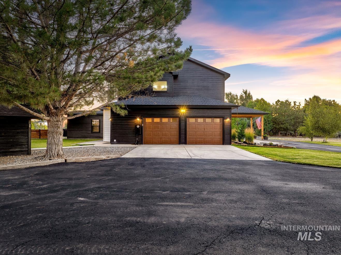 View of front of property featuring concrete driveway and a garage
