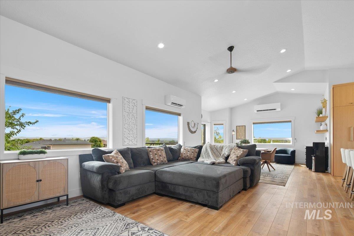 Great room featuring ceiling fan, plenty of natural light, recessed lighting, vaulted ceiling, and light wood-type flooring