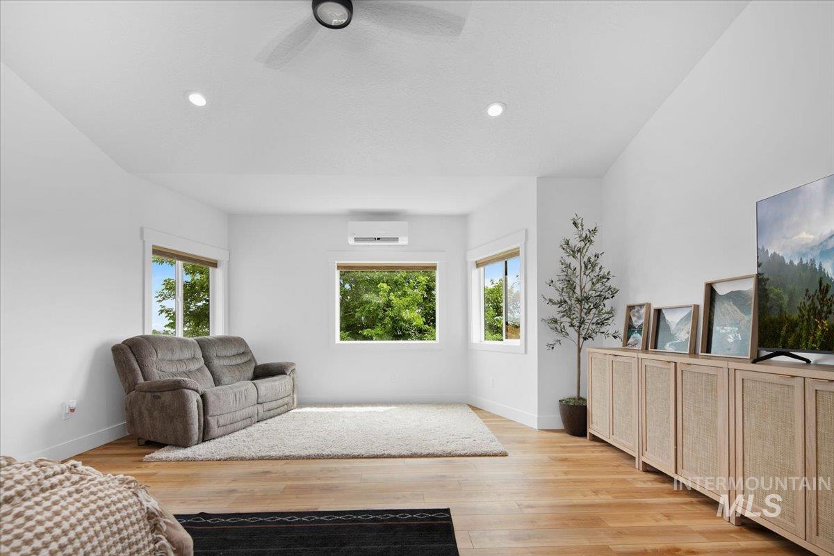 Huge Master suite with light wood-style flooring, ceiling fan, and recessed lighting