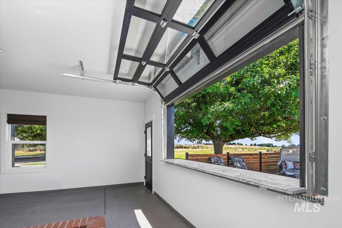 View of patio / terrace through roll up bar at indoor pool.
