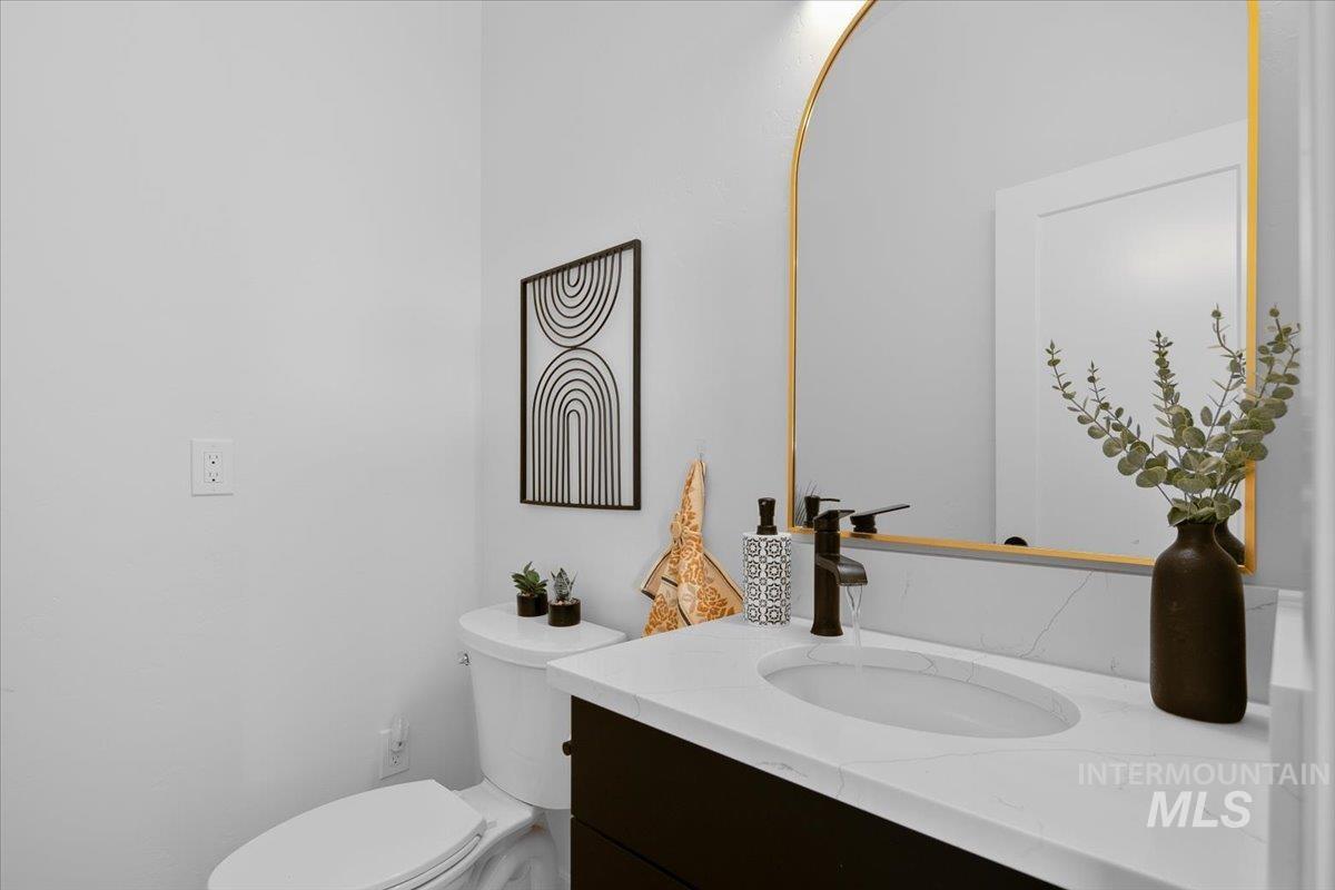 Half bathroom featuring vanity and toilet