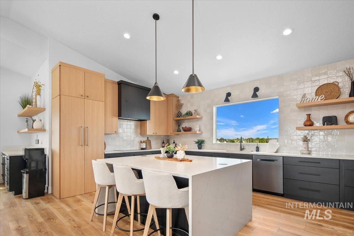 Kitchen featuring open shelves, light brown cabinets, a breakfast island, light countertops, and decorative backsplash