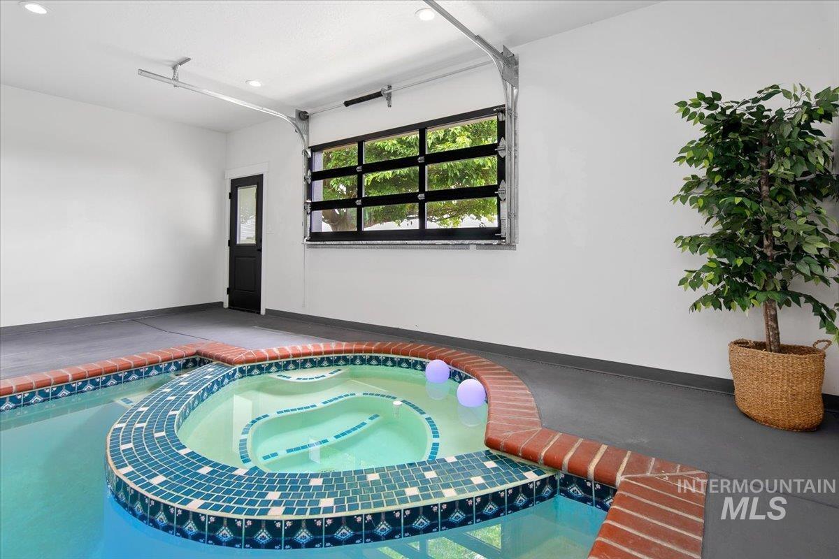 View of pool with an in-ground hot tub