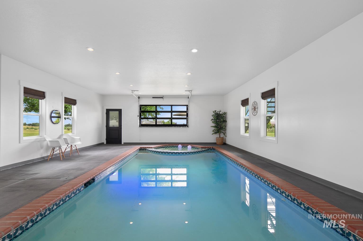 View of the indoor pool with connected hot tub