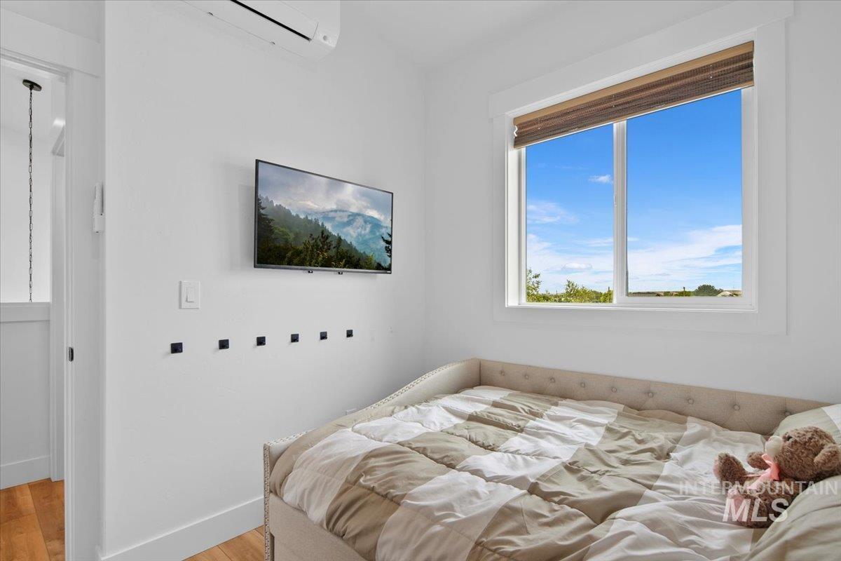 Bedroom or Office featuring with light LVP flooring and a wall unit AC