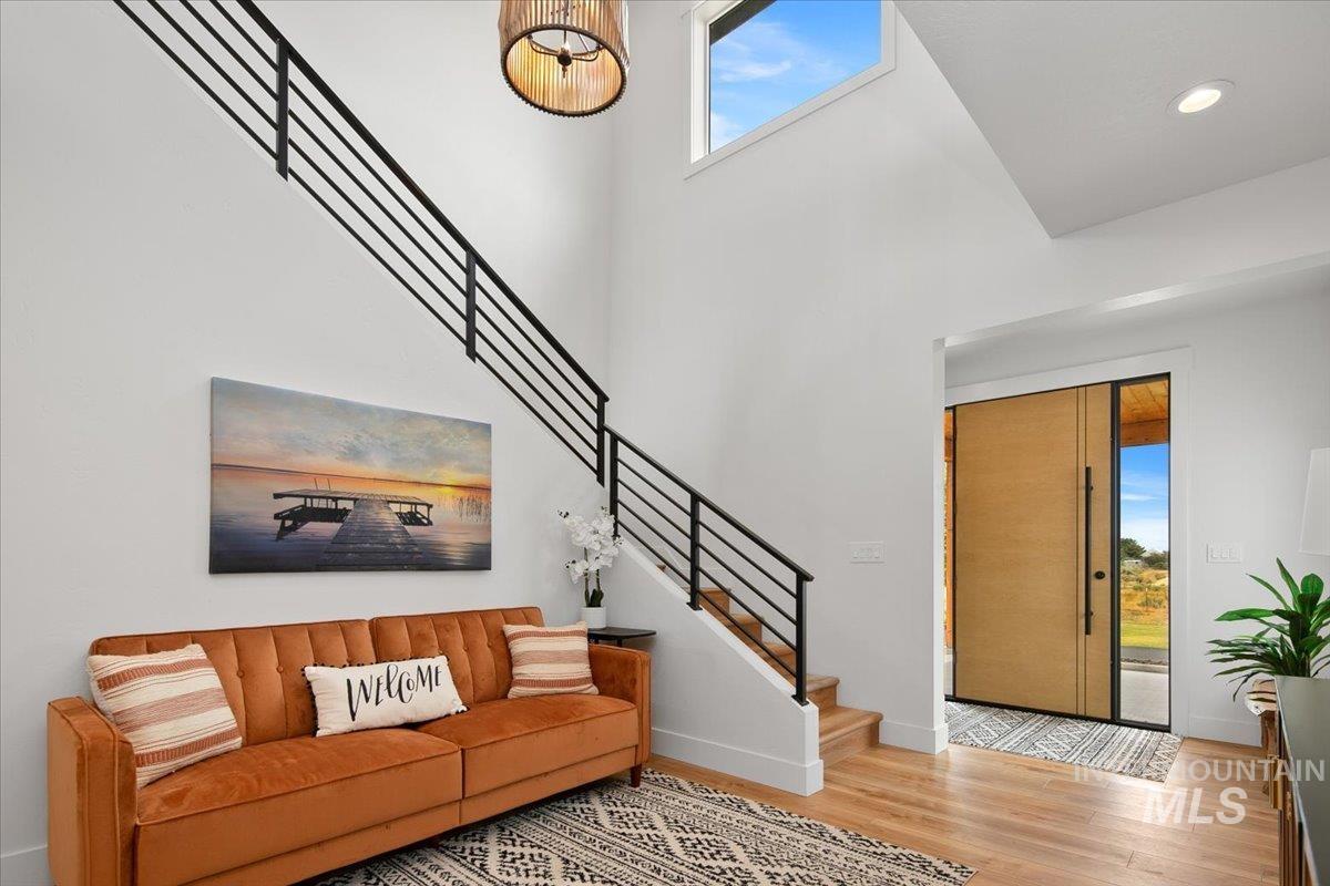 Foyer area featuring wood finished floors, stairs, a high ceiling, and recessed lighting