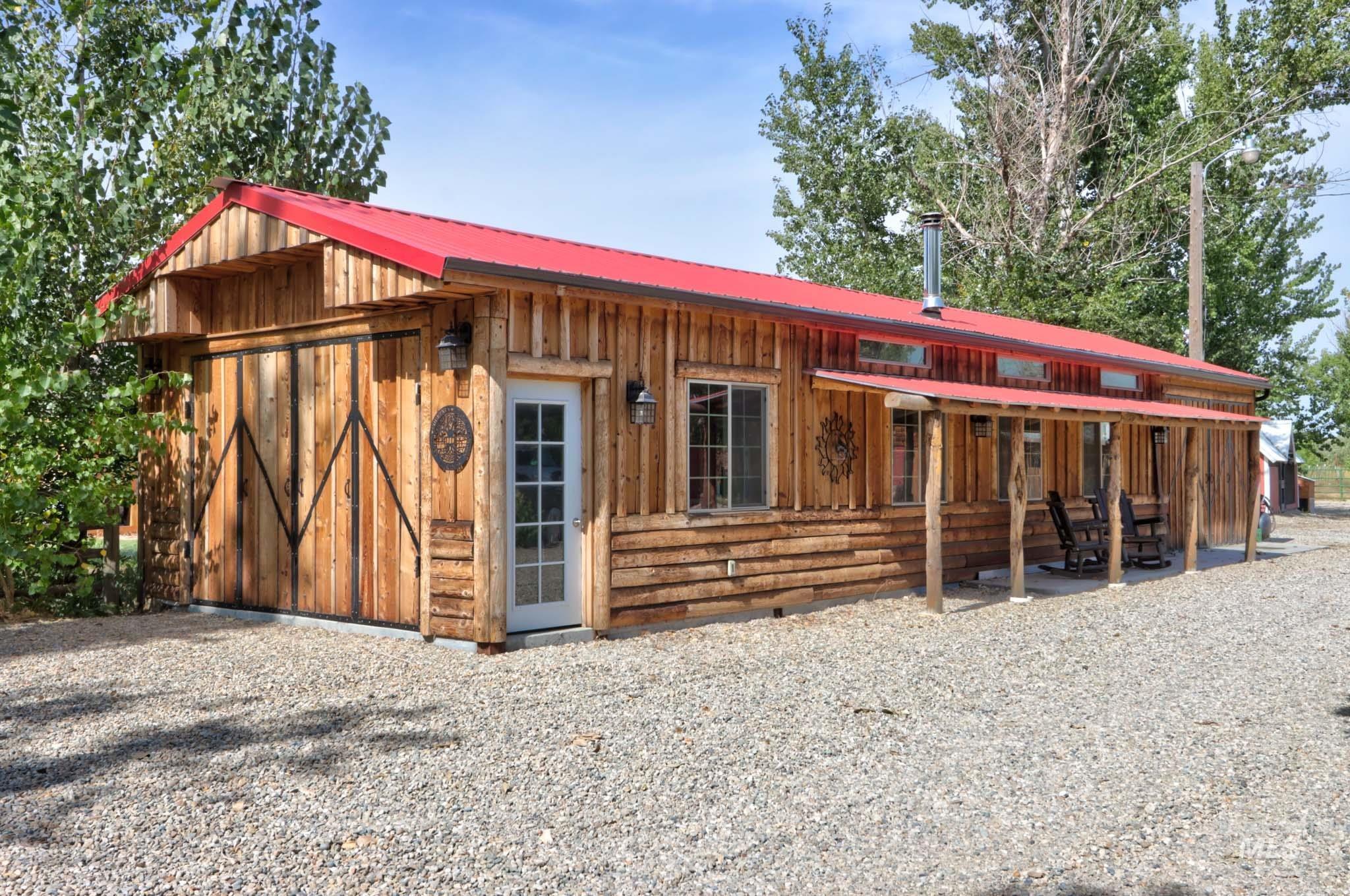 View of front of house with board and batten siding, a metal roof, and an outdoor structure