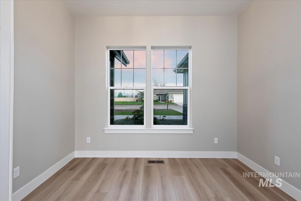 Spare room with baseboards and light wood-type flooring
