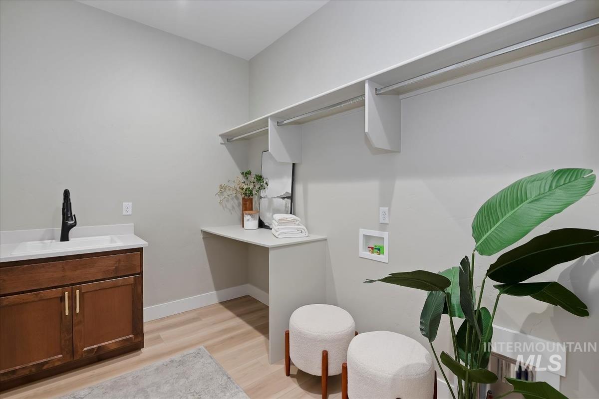 Washroom featuring washer hookup and light wood finished floors