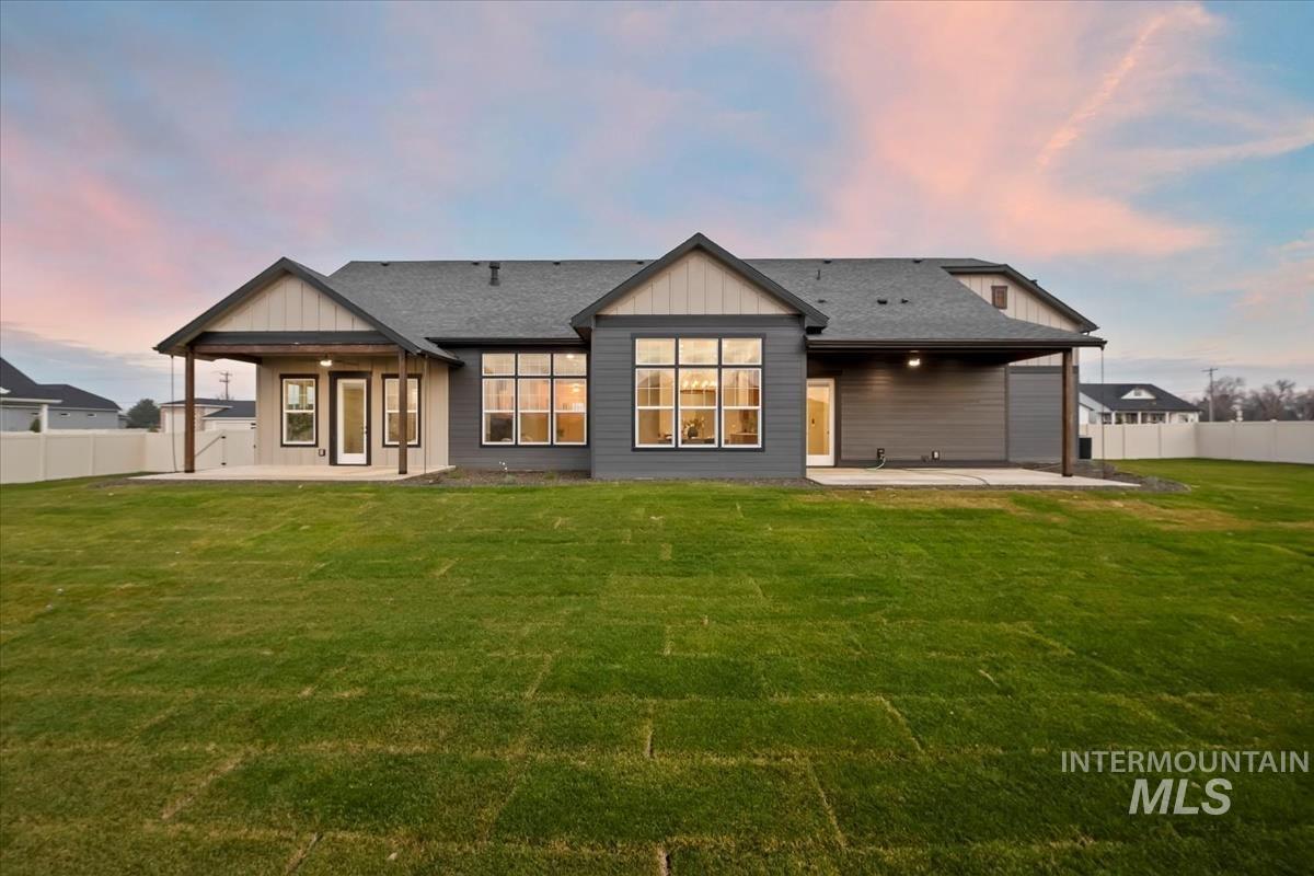 Rear view of house featuring a patio and roof with shingles