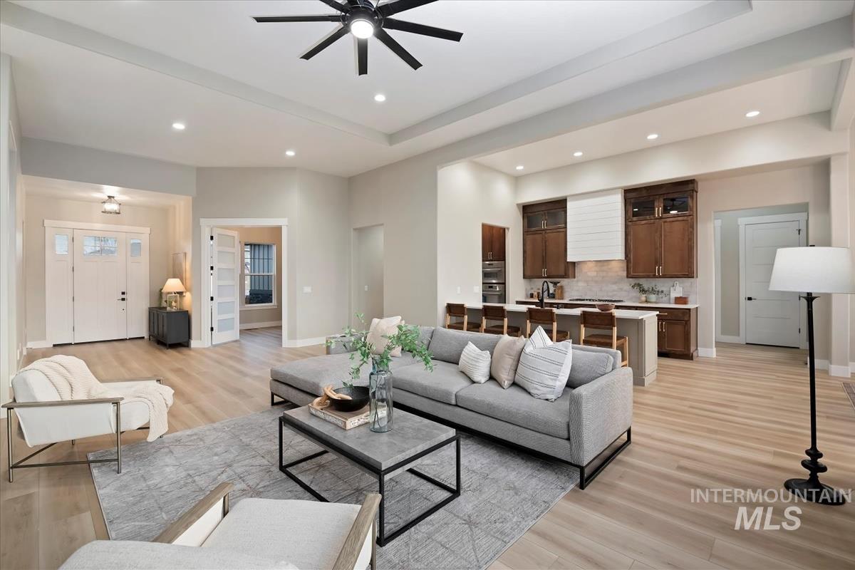 Living room with light wood-type flooring, ceiling fan, and recessed lighting