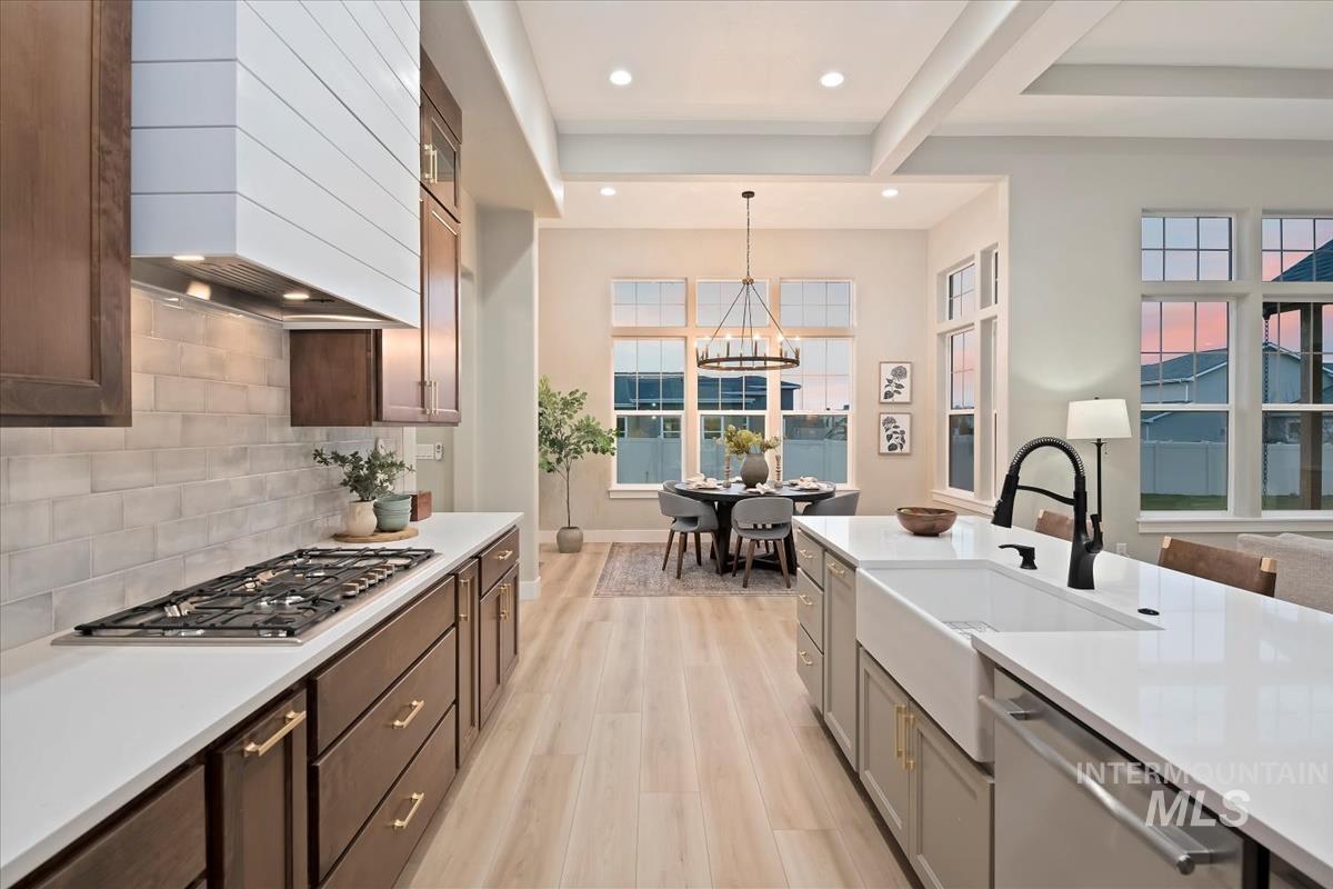 Kitchen featuring custom range hood, pendant lighting, stainless steel appliances, light wood-style floors, and recessed lighting