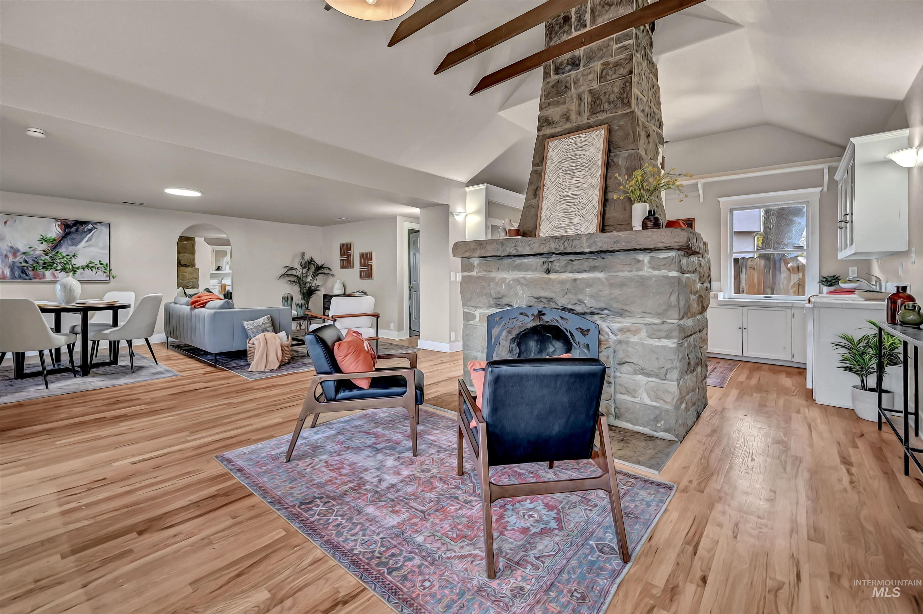 Statement stone fireplace anchors the space, with the kitchen behind it and the living room to the left for an easy, cohesive layout.