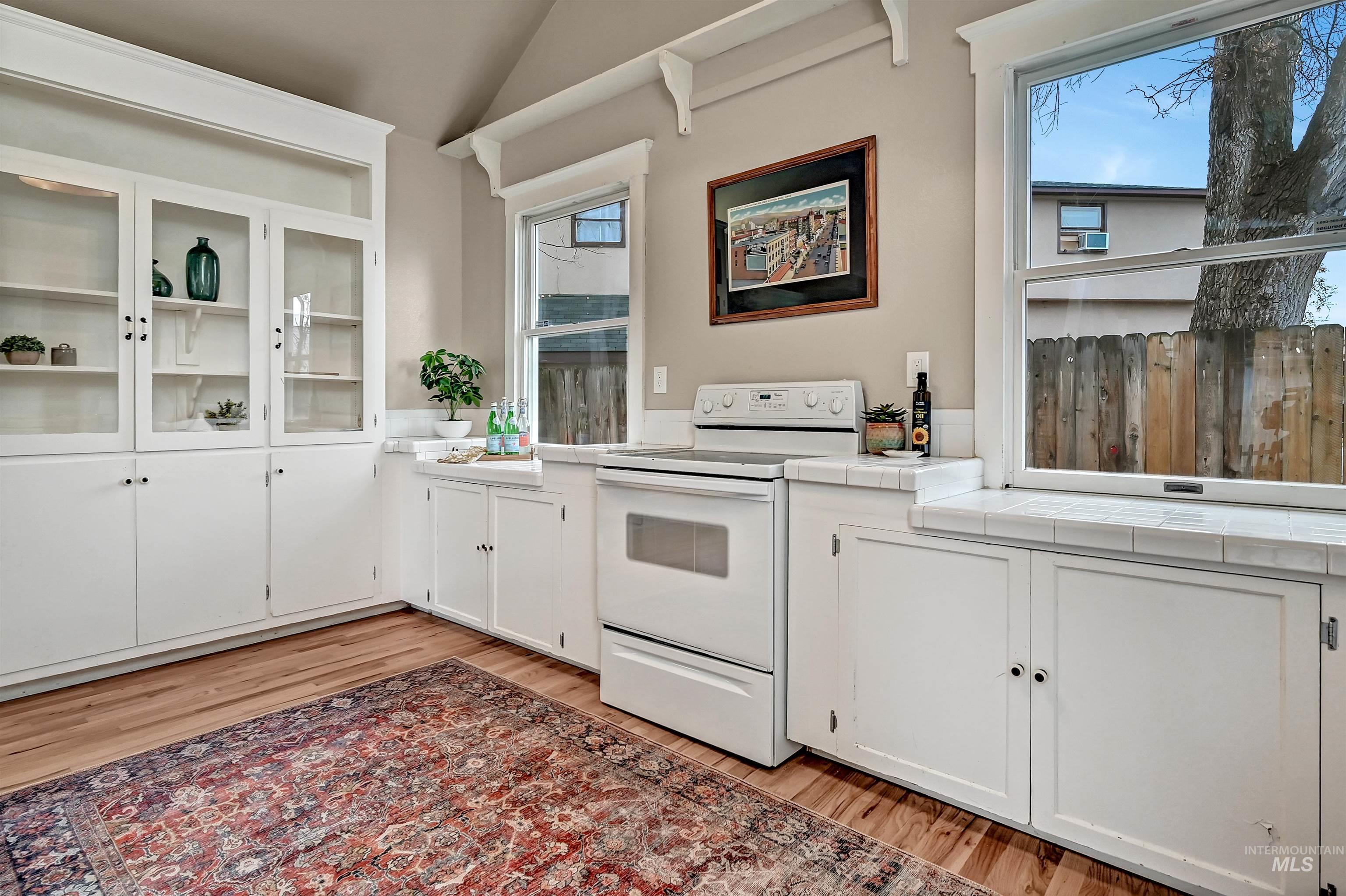 Bright, open kitchen featuring glass-front cabinetry and expansive windows that make the space feel airy and welcoming.