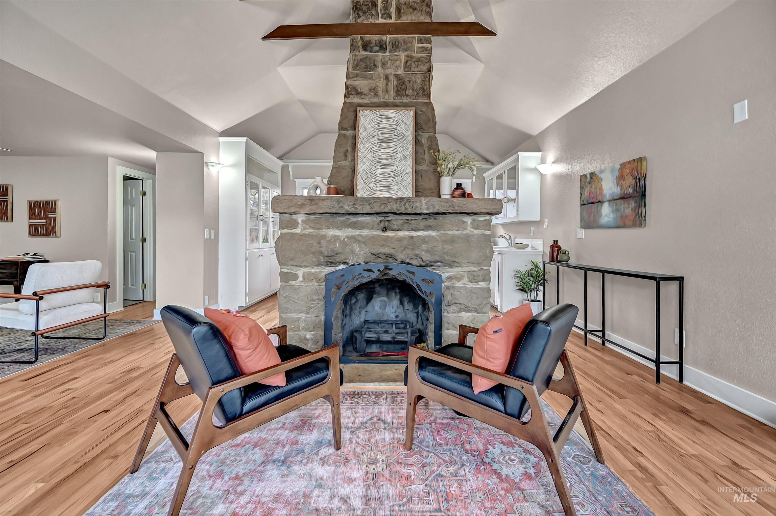 Statement stone fireplace creates a strong focal point for the home, paired with warm hardwood floors and a comfortable, airy layout that feels inviting and stylish.
