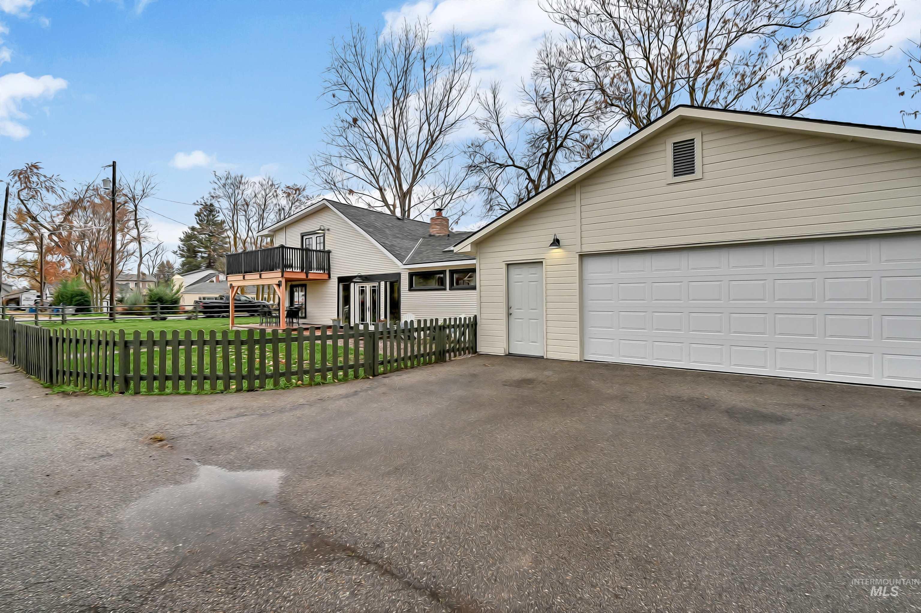 Ample driveway parking and an oversized detached garage, set beside the fenced yard for added convenience. RV parking is to the right of the garage.