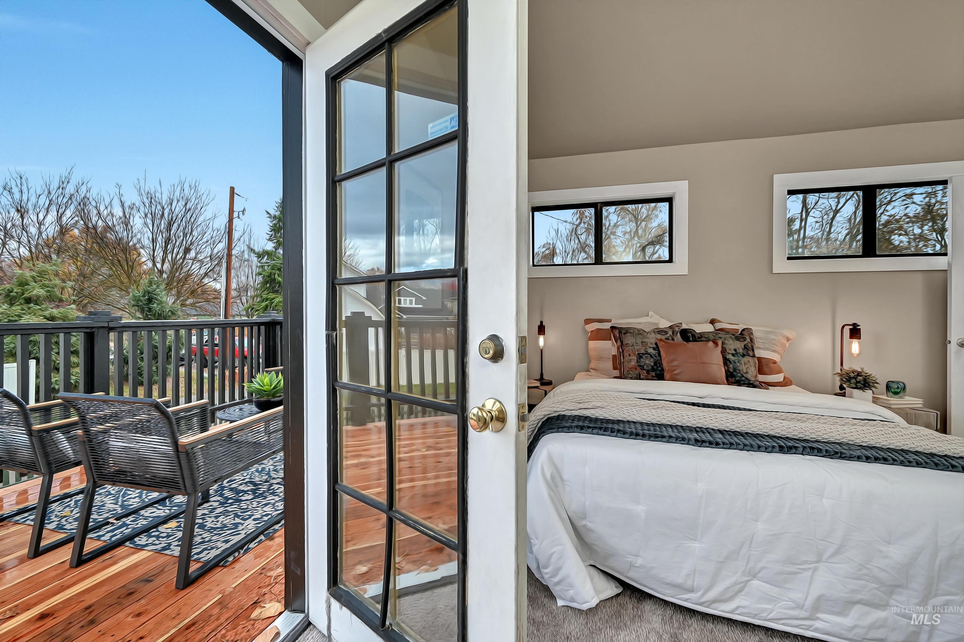 French doors bring the outdoors in, connecting the upstairs primary ensuite to the newly rebuilt deck for a private retreat.