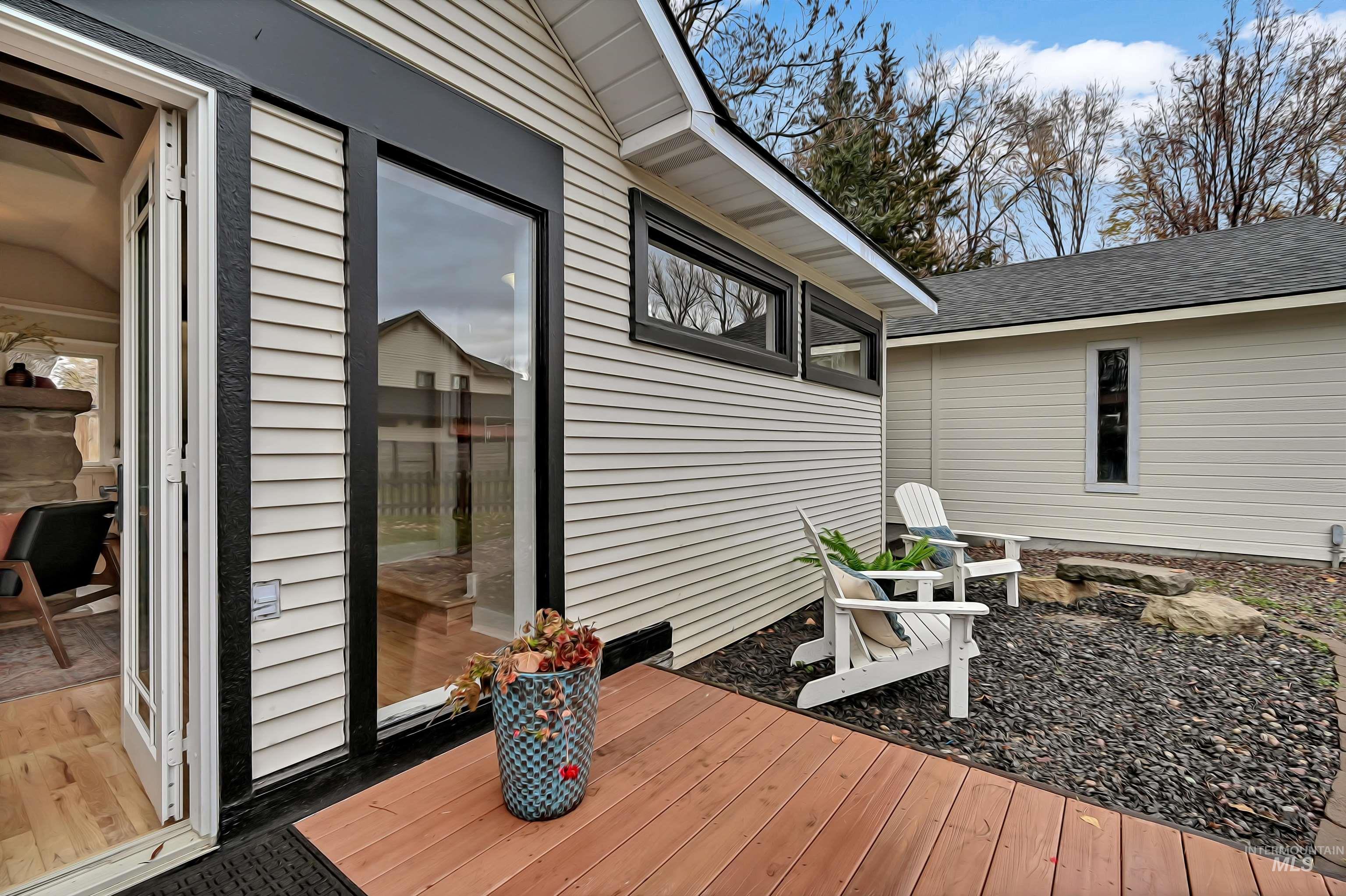 Inviting indoor?outdoor flow with French doors opening to a spacious deck. Covered dining area below the upper balcony offers a great spot for entertaining. Warm natural light and clean finishes visible inside.