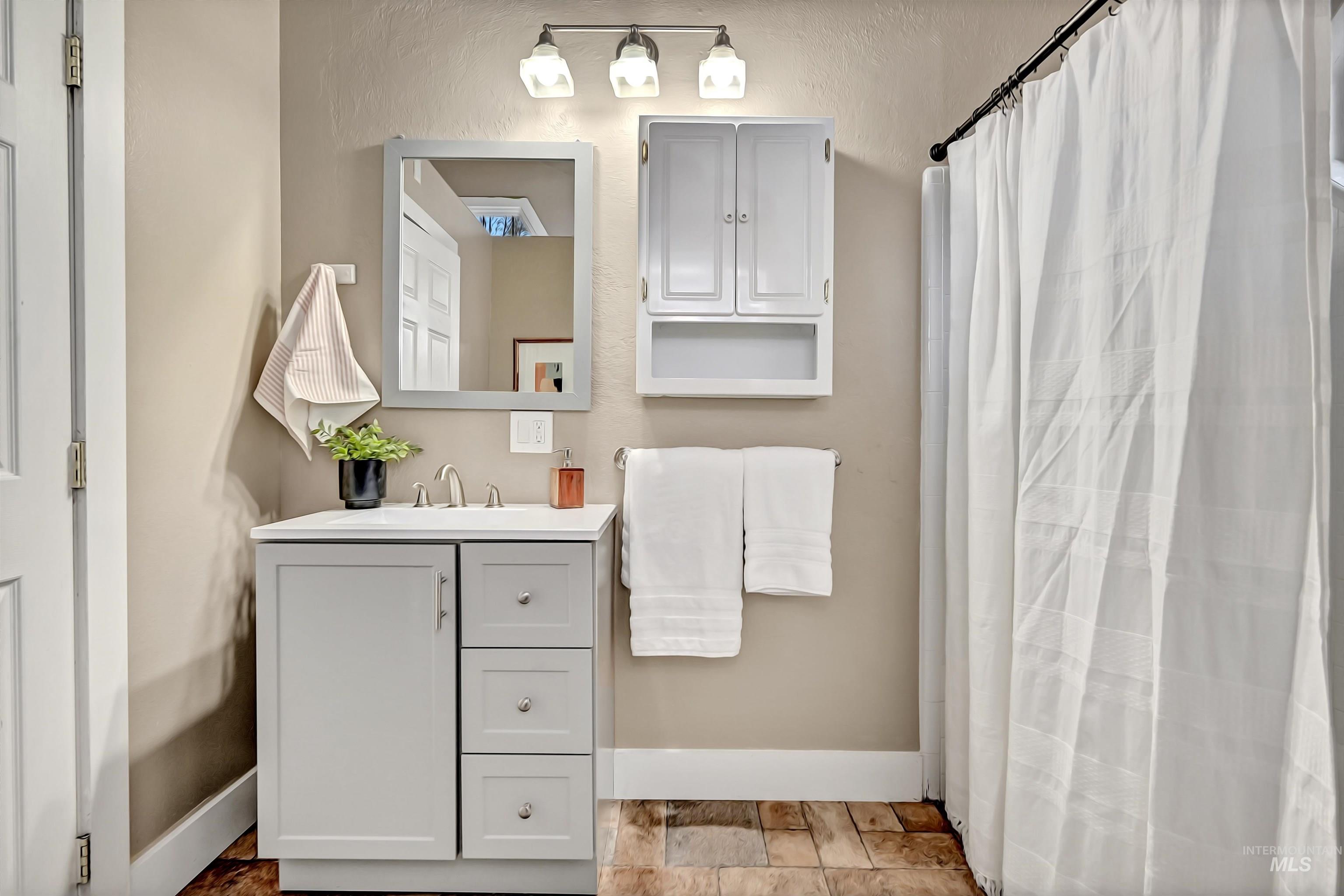 Main-level bathroom with a tub and shower plus access to the laundry room.