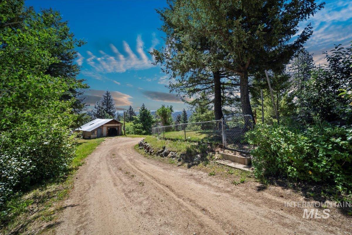 View of dirt / gravel road featuring an outbuilding