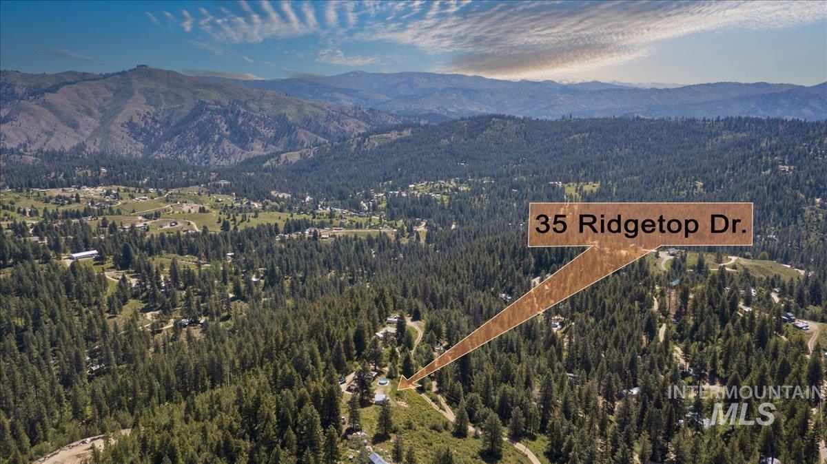 View of property location with mountains and a heavily wooded area