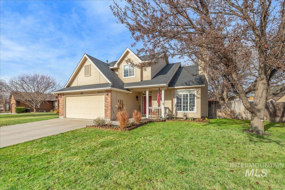 Traditional home with covered porch, concrete driveway, a shingled roof, an attached garage, and brick siding